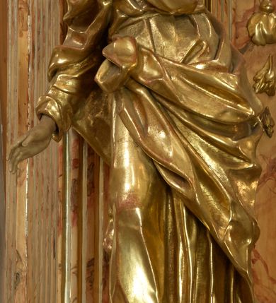 Zdjęcie nr 8: Retabulum architektoniczne, jednoosiowe, jednokondygnacyjne, ze zwieńczeniem,  posadowione na wysokim cokole. Nastawa ujęta ukośnie ustawionymi połówkami filarów na tle pilastrów, o kapitelach kompozytowych, podtrzymujących wydatne, przełamujące się nad nimi belkowanie z impostami i zwróconymi ku przodowi naczółkami, na których uskrzydlone, nagie putta, przepasane tkaninami. Zwieńczenie o lekko wklęsłych bokach zakończone gzymsem w formie łuku nadwieszonego. W partii fryzu kartusz ujęty wolutami, z lambrekinem u dołu, z muszlą palmetową u góry. W zwieńczeniu Oko Opatrzności na tle obłoków i promienistej glorii oraz dwie uskrzydlone główki anielskie. Dekorację ornamentalną tworzą kratki regencyjne, kampanule i muszle palmetowe. W części środkowej, we wnęce prostokątnej zamkniętej łukiem nadwieszonym półkolistym, w profilowanym obramieniu obraz Św. Katarzyna w profilowanej, prostokątnej ramie, nad nią rozłożysta palmeta. Wnęka ujęta kampanulami i gałązkami palmowymi. Po bokach nastawy dwie niezidentyfikowane postacie mężczyzn, całopostaciowe, w długich, silnie drapowanych sukniach, o wyrazistych twarzach, z krótkim zarostem i lekko falującymi włosami. Polichromia imitująca marmoryzację w odcieniach jasnych brązów, czerwieni i zieleni, figury o naturalnych karnacjach, złocenia szat figur i ornamentów, srebrzenia drobnych detali ornamentalnych.      
     
