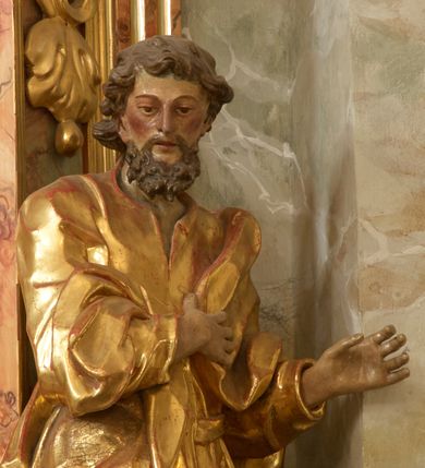 Zdjęcie nr 10: Retabulum architektoniczne, jednoosiowe, jednokondygnacyjne, ze zwieńczeniem,  posadowione na wysokim cokole. Nastawa ujęta ukośnie ustawionymi połówkami filarów na tle pilastrów, o kapitelach kompozytowych, podtrzymujących wydatne, przełamujące się nad nimi belkowanie z impostami i zwróconymi ku przodowi naczółkami, na których uskrzydlone, nagie putta, przepasane tkaninami. Zwieńczenie o lekko wklęsłych bokach zakończone gzymsem w formie łuku nadwieszonego. W partii fryzu kartusz ujęty wolutami, z lambrekinem u dołu, z muszlą palmetową u góry. W zwieńczeniu Oko Opatrzności na tle obłoków i promienistej glorii oraz dwie uskrzydlone główki anielskie. Dekorację ornamentalną tworzą kratki regencyjne, kampanule i muszle palmetowe. W części środkowej, we wnęce prostokątnej zamkniętej łukiem nadwieszonym półkolistym, w profilowanym obramieniu obraz Św. Katarzyna w profilowanej, prostokątnej ramie, nad nią rozłożysta palmeta. Wnęka ujęta kampanulami i gałązkami palmowymi. Po bokach nastawy dwie niezidentyfikowane postacie mężczyzn, całopostaciowe, w długich, silnie drapowanych sukniach, o wyrazistych twarzach, z krótkim zarostem i lekko falującymi włosami. Polichromia imitująca marmoryzację w odcieniach jasnych brązów, czerwieni i zieleni, figury o naturalnych karnacjach, złocenia szat figur i ornamentów, srebrzenia drobnych detali ornamentalnych.      
     
