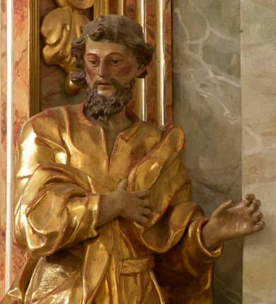 Zdjęcie nr 13: Retabulum architektoniczne, jednoosiowe, jednokondygnacyjne, ze zwieńczeniem,  posadowione na wysokim cokole. Nastawa ujęta ukośnie ustawionymi połówkami filarów na tle pilastrów, o kapitelach kompozytowych, podtrzymujących wydatne, przełamujące się nad nimi belkowanie z impostami i zwróconymi ku przodowi naczółkami, na których uskrzydlone, nagie putta, przepasane tkaninami. Zwieńczenie o lekko wklęsłych bokach zakończone gzymsem w formie łuku nadwieszonego. W partii fryzu kartusz ujęty wolutami, z lambrekinem u dołu, z muszlą palmetową u góry. W zwieńczeniu Oko Opatrzności na tle obłoków i promienistej glorii oraz dwie uskrzydlone główki anielskie. Dekorację ornamentalną tworzą kratki regencyjne, kampanule i muszle palmetowe. W części środkowej, we wnęce prostokątnej zamkniętej łukiem nadwieszonym półkolistym, w profilowanym obramieniu obraz Św. Katarzyna w profilowanej, prostokątnej ramie, nad nią rozłożysta palmeta. Wnęka ujęta kampanulami i gałązkami palmowymi. Po bokach nastawy dwie niezidentyfikowane postacie mężczyzn, całopostaciowe, w długich, silnie drapowanych sukniach, o wyrazistych twarzach, z krótkim zarostem i lekko falującymi włosami. Polichromia imitująca marmoryzację w odcieniach jasnych brązów, czerwieni i zieleni, figury o naturalnych karnacjach, złocenia szat figur i ornamentów, srebrzenia drobnych detali ornamentalnych.      
     
