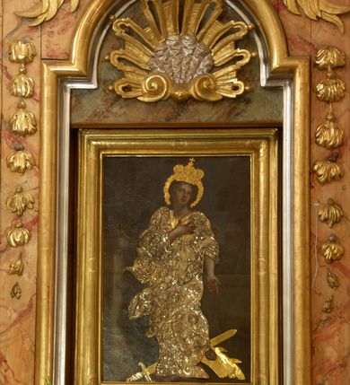 Zdjęcie nr 3: Retabulum architektoniczne, jednoosiowe, jednokondygnacyjne, ze zwieńczeniem,  posadowione na wysokim cokole. Nastawa ujęta ukośnie ustawionymi połówkami filarów na tle pilastrów, o kapitelach kompozytowych, podtrzymujących wydatne, przełamujące się nad nimi belkowanie z impostami i zwróconymi ku przodowi naczółkami, na których uskrzydlone, nagie putta, przepasane tkaninami. Zwieńczenie o lekko wklęsłych bokach zakończone gzymsem w formie łuku nadwieszonego. W partii fryzu kartusz ujęty wolutami, z lambrekinem u dołu, z muszlą palmetową u góry. W zwieńczeniu Oko Opatrzności na tle obłoków i promienistej glorii oraz dwie uskrzydlone główki anielskie. Dekorację ornamentalną tworzą kratki regencyjne, kampanule i muszle palmetowe. W części środkowej, we wnęce prostokątnej zamkniętej łukiem nadwieszonym półkolistym, w profilowanym obramieniu obraz Św. Katarzyna w profilowanej, prostokątnej ramie, nad nią rozłożysta palmeta. Wnęka ujęta kampanulami i gałązkami palmowymi. Po bokach nastawy dwie niezidentyfikowane postacie mężczyzn, całopostaciowe, w długich, silnie drapowanych sukniach, o wyrazistych twarzach, z krótkim zarostem i lekko falującymi włosami. Polichromia imitująca marmoryzację w odcieniach jasnych brązów, czerwieni i zieleni, figury o naturalnych karnacjach, złocenia szat figur i ornamentów, srebrzenia drobnych detali ornamentalnych.      
     
