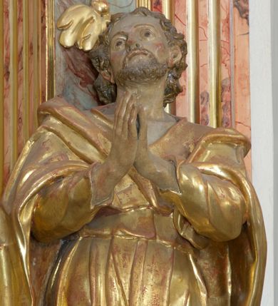 Zdjęcie nr 6: Retabulum architektoniczne, jednoosiowe, jednokondygnacyjne, ze zwieńczeniem, wzniesione na wysokim cokole. Nastawa ujęta ukośnie ustawionymi połówkami filarów na tle pilastrów, o kapitelach kompozytowych, podtrzymujących wydatne, przełamujące się nad nimi belkowanie z impostami i zwróconymi ku przodowi naczółkami, na których siedzą uskrzydlone, nagie putta, przepasane tkaninami. Zwieńczenie o lekko wklęsłych bokach zakończone gzymsem w formie łuku nadwieszonego. W partii fryzu kartusz ujęty wolutami, z lambrekinem u dołu z muszlą palmetową u góry. W zwieńczeniu gołębica Ducha Świętego na tle obłoków i promienistej glorii. Dekorację ornamentalną tworzą kratki regencyjne, kampanule i muszle palmetowe. W części środkowej obraz Matki Boskiej z Dzieciątkiem w typie Matki Boskiej Śnieżnej w drewnianej, złoconej sukience z koronami na głowie. Obraz z profilowanej ramie, złoconej i srebrzonej, ujętej po bokach zwisami z liści i kwiatów. Ponad obrazem rozłożysta muszla palmetowa. Po bokach nastawy dwie niezidentyfikowane postacie mężczyzn, całopostaciowe, w długich sukniach, z płaszczami zarzuconymi na ramiona, jedna z otwartą księgą w prawej dłoni, druga z rękoma złożonymi w geście modlitwy. Polichromia imitująca marmoryzację w odcieniach jasnych brązów, czerwieni i zieleni, figury o naturalnych karnacjach, złocenia szat figur i ornamentów, srebrzenia drobnych detali ornamentalnych.      


