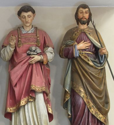 Zdjęcie nr 1: Figura pełna na cokole przedstawiająca św. Walentego. Święty stoi frontalnie, spoglądając przed siebie. Ma trójkątną twarz, małe oczy, wąski nos, niewielkie usta i krótkie, ciemne włosy. Prawą rękę wyciąga przed siebie w delikatnym geście, lewą przytrzymuje zamkniętą księgę. Ubrany jest w białą komżę zdobioną przy rękawach i dolnej krawędzi szerokim pasem koronki oraz złoty ornat dekorowany motywami winnej latorośli z monogramami Chrystusa na kolumnie – pionowym pasie biegnącym przez środek szaty. Spod ornatu wystają końce złotej stuły zakończonej krzyżami równoramiennymi i frędzlami, przez lewe przedramię przewieszony ma manipularz. 
Na cokole napis „S(anc)t(us) Valentinus”.
