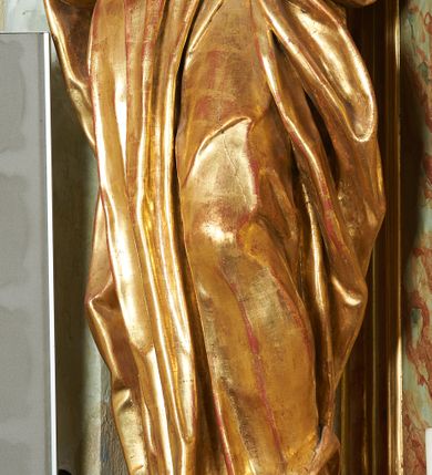 Zdjęcie nr 10: Figura ukazuje mężczyznę w całej postaci, w kontrapoście, ubranego w długą suknię przewiązaną w pasie i płaszcz spięty na piersiach, z otwartą księgą na prawej dłoni, z lewą przytrzymującą na biodrach płaszcz. Głowa zwrócona w lewo, ku górze, okolona długą, falującą brodą. 