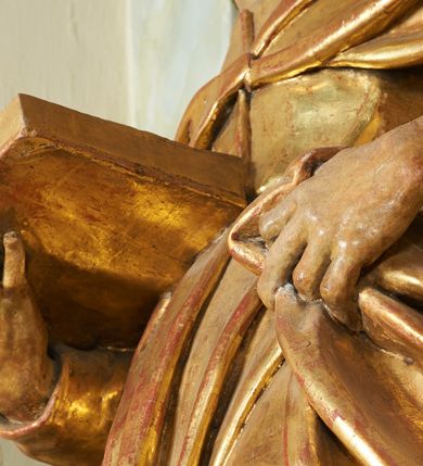 Zdjęcie nr 9: Figura ukazuje mężczyznę w całej postaci, w kontrapoście, ubranego w długą suknię przewiązaną w pasie i płaszcz spięty na piersiach, z otwartą księgą na prawej dłoni, z lewą przytrzymującą na biodrach płaszcz. Głowa zwrócona w lewo, ku górze, okolona długą, falującą brodą. 