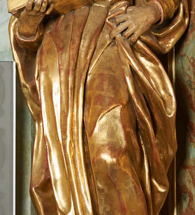 Zdjęcie nr 3: Figura ukazuje mężczyznę w całej postaci, w kontrapoście, ubranego w długą suknię przewiązaną w pasie i płaszcz spięty na piersiach, z otwartą księgą na prawej dłoni, z lewą przytrzymującą na biodrach płaszcz. Głowa zwrócona w lewo, ku górze, okolona długą, falującą brodą. 