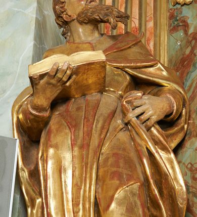 Zdjęcie nr 8: Figura ukazuje mężczyznę w całej postaci, w kontrapoście, ubranego w długą suknię przewiązaną w pasie i płaszcz spięty na piersiach, z otwartą księgą na prawej dłoni, z lewą przytrzymującą na biodrach płaszcz. Głowa zwrócona w lewo, ku górze, okolona długą, falującą brodą. 