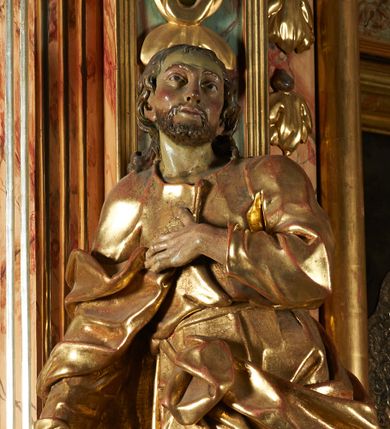 Zdjęcie nr 1: Rzeźba z ołtarza św. Katarzyny przedstawia świętego w lekkim wykroku z prawą nogą nieco wysuniętą do przodu. Wzrok zwrócony przed siebie, włosy długie, broda krótka. Lewa ręka jest położona na piersi, zaś prawa opuszczona i lekko odsunięta od ciała. Płaszcz i tunika bogato drapowane i złocone.