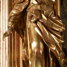 Zdjęcie nr 1: Rzeźba z ołtarza św. Katarzyny przedstawia świętego w lekkim wykroku z prawą nogą nieco wysuniętą do przodu. Wzrok zwrócony przed siebie, włosy długie, broda krótka. Lewa ręka jest położona na piersi, zaś prawa opuszczona i lekko odsunięta od ciała. Płaszcz i tunika bogato drapowane i złocone.