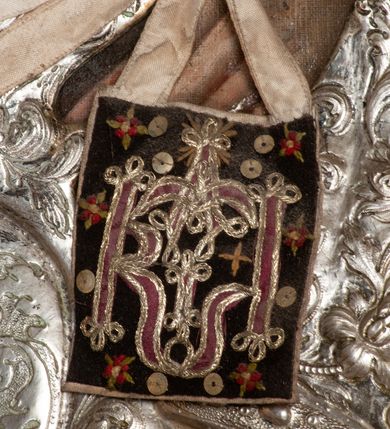 Zdjęcie nr 16: Ołtarz przyścienny, architektoniczny, jednokondygnacyjny ze zwieńczeniem, trójosiowy z bramkami. Mensa murowana prostopadłościenna, antepedium drewniane w złoconej ramie dekorowanej akantem. W jego polu medalion z monogramem maryjnym w glorii promienistej, otoczony przestylizowaną winoroślą. Tabernakulum w osi, metalowe, prostopadłościenne, jednodrzwiczkowe, z przedstawieniem kielicha z hostią. Retabulum ołtarzowe drewniane na cokole. Pole ołtarza z prostokątną, profilowaną ramą zamkniętą łukiem wklęsło-wypukłym z uskokiem. Mieści obraz Matki Boskiej Szkaplerznej, w bogatej akantowo-kwiatowej ramie z umieszczonym u góry, w osi owalnym obrazem Boga Ojca; zasuwany obrazami św. Józefa oraz św. Izydora Oracza. Pole jest ujęte ustawionymi na wysokich cokołach dekorowanych akantem, kolumnami o trzonach wypełnionych ornamentem roślinno-kwiatowym o układzie kandelabrowym oraz u podstawy z pełnoplastycznymi, uskrzydlonymi główkami aniołów; kapitele kompozytowe. Kolumny dźwigają niepełne, wyniesione pośrodku belkowanie, z odcinkami półkolistego przyczółka, na którym siedzą pełnoplastyczne, złocone figurki puttów. Fryz dekorowany akantem. W zwieńczeniu obraz św. Antoniego Padewskiego, prostokątny, zamknięty półkoliście, ujęty akantowymi wolutami. W bocznych osiach, ponad bramkami, prostokątne obrazy z lewej: św. Anny, z prawej: św. Joachima, dekorowane złoconym, ażurowym zwieńczeniem z kartuszy ujętych akantem. Ołtarz utrzymany w odcieniach beżu i szarości ze złoceniami w partiach ornamentów oraz w załamaniach profili architektonicznych.