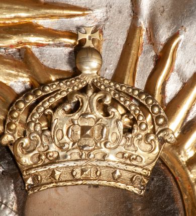 Zdjęcie nr 8: Ołtarz przyścienny, architektoniczny, jednokondygnacyjny ze zwieńczeniem, trójosiowy z bramkami. Mensa murowana prostopadłościenna, antepedium drewniane w złoconej ramie dekorowanej akantem. W jego polu medalion z monogramem maryjnym w glorii promienistej, otoczony przestylizowaną winoroślą. Tabernakulum w osi, metalowe, prostopadłościenne, jednodrzwiczkowe, z przedstawieniem kielicha z hostią. Retabulum ołtarzowe drewniane na cokole. Pole ołtarza z prostokątną, profilowaną ramą zamkniętą łukiem wklęsło-wypukłym z uskokiem. Mieści obraz Matki Boskiej Szkaplerznej, w bogatej akantowo-kwiatowej ramie z umieszczonym u góry, w osi owalnym obrazem Boga Ojca; zasuwany obrazami św. Józefa oraz św. Izydora Oracza. Pole jest ujęte ustawionymi na wysokich cokołach dekorowanych akantem, kolumnami o trzonach wypełnionych ornamentem roślinno-kwiatowym o układzie kandelabrowym oraz u podstawy z pełnoplastycznymi, uskrzydlonymi główkami aniołów; kapitele kompozytowe. Kolumny dźwigają niepełne, wyniesione pośrodku belkowanie, z odcinkami półkolistego przyczółka, na którym siedzą pełnoplastyczne, złocone figurki puttów. Fryz dekorowany akantem. W zwieńczeniu obraz św. Antoniego Padewskiego, prostokątny, zamknięty półkoliście, ujęty akantowymi wolutami. W bocznych osiach, ponad bramkami, prostokątne obrazy z lewej: św. Anny, z prawej: św. Joachima, dekorowane złoconym, ażurowym zwieńczeniem z kartuszy ujętych akantem. Ołtarz utrzymany w odcieniach beżu i szarości ze złoceniami w partiach ornamentów oraz w załamaniach profili architektonicznych.