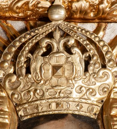 Zdjęcie nr 7: Ołtarz przyścienny, architektoniczny, jednokondygnacyjny ze zwieńczeniem, trójosiowy z bramkami. Mensa murowana prostopadłościenna, antepedium drewniane w złoconej ramie dekorowanej akantem. W jego polu medalion z monogramem maryjnym w glorii promienistej, otoczony przestylizowaną winoroślą. Tabernakulum w osi, metalowe, prostopadłościenne, jednodrzwiczkowe, z przedstawieniem kielicha z hostią. Retabulum ołtarzowe drewniane na cokole. Pole ołtarza z prostokątną, profilowaną ramą zamkniętą łukiem wklęsło-wypukłym z uskokiem. Mieści obraz Matki Boskiej Szkaplerznej, w bogatej akantowo-kwiatowej ramie z umieszczonym u góry, w osi owalnym obrazem Boga Ojca; zasuwany obrazami św. Józefa oraz św. Izydora Oracza. Pole jest ujęte ustawionymi na wysokich cokołach dekorowanych akantem, kolumnami o trzonach wypełnionych ornamentem roślinno-kwiatowym o układzie kandelabrowym oraz u podstawy z pełnoplastycznymi, uskrzydlonymi główkami aniołów; kapitele kompozytowe. Kolumny dźwigają niepełne, wyniesione pośrodku belkowanie, z odcinkami półkolistego przyczółka, na którym siedzą pełnoplastyczne, złocone figurki puttów. Fryz dekorowany akantem. W zwieńczeniu obraz św. Antoniego Padewskiego, prostokątny, zamknięty półkoliście, ujęty akantowymi wolutami. W bocznych osiach, ponad bramkami, prostokątne obrazy z lewej: św. Anny, z prawej: św. Joachima, dekorowane złoconym, ażurowym zwieńczeniem z kartuszy ujętych akantem. Ołtarz utrzymany w odcieniach beżu i szarości ze złoceniami w partiach ornamentów oraz w załamaniach profili architektonicznych.