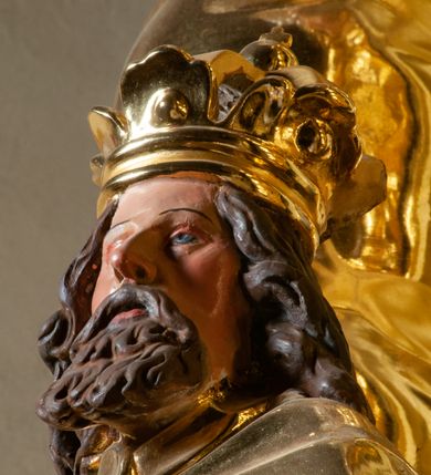 Zdjęcie nr 105: Drewniany, przyścienny ołtarz o formach architektonicznych, jednoosiowy, jednokondygnacyjny ze zwieńczeniem. Mensa murowana w kształcie prostopadłościanu zwieńczonego profilowanym gzymsem; antepedium prostokątne, w drewnianej, płaskorzeźbionej w motywy akantowe, złoconej ramie, dwustronne. Awers tłoczony, srebrzony, wykonany w technice papier mâché; rewers z malowanym na desce wyobrażeniem Veraicon na tle narzędzi męki. Tabernakulum na osi, złożone z mosiężnej, złoconej, sześciobocznej skrzynki w rozbudowanej, drewnianej obudowie o formach architektonicznych. Na nim tron wystawienia w kształcie niszy dekorowanej kratką, nakrytej kopułką z latarnią i przysłoniętej złapanymi po bokach kotarami. Na latarni rzeźbione przedstawienie pelikana karmiącego pisklęta własną krwią. Skrzynkę z tronem ulokowano na tle parawanu ustawionego na podwójnym cokole, ażurowego w górnej części, wypełnionego dekoracją roślinną, złączonego z kopułka spływami. 
Retabulum ołtarzowe drewniane wsparte na wysokim, dwudzielnym, murowanym cokole. Cokół w obudowie drewnianej, jego kondygnacje wydzielone wydatnymi, silnie występującymi przed lico gzymsami; mocno wysunięte ku przodowi części przednie. Ich lica z prostokątnymi płycinami mieszczącymi suchy akant; w części środkowej drugiej kondygnacji cokołu, dodatkowo pełnoplastyczne główki puttów. Na cokole ustawione zdwojone, złocone kolumny o skręconych trzonach i kompozytowych kapitelach. Pomiędzy nimi płyciny wypełnione dekoracją w formie podwieszonego wieńca, u jego szczytu putta pełniące rolę atlantów. Na tle płycin ustawione drewniane, złocone figury z lewej św. Zygmunta i z prawej św. Marii Magdaleny – patronów kościoła. Pole ołtarza z prostokątną niszą zamkniętą łukiem wyniesionym; ujętą płaskorzeźbioną, złoconą ramą zdobioną suchym akantem. W niszy pełnoplastyczny, polichromowany i złocony krucyfiks na aksamitnym tle, flankowany przez płaskorzeźbione wyobrażenia słońca i księżyca. Nisza zasuwana obrazem z Przemienieniem na górze Tabor, w drewnianej, złoconej sukience. Kolumny dźwigają pełne, wyłamane na osiach podpór belkowanie, z wydatnym, silnie profilowanym gzymsem; na jego osi złocony monogram „IHS” w otoku ze srebrzonych obłoków na tle promienistej glorii. Całość wieńczą fragmenty przerwanego przyczółka o formach wklęsło-wypukłych, z ażurową dekoracją z suchego akantu. Pomiędzy ramionami przyczółka złocona gloria promienista, w centrum której płaskorzeźbiona postać Boga Ojca siedzącego na srebrzonym obłoku ze srebrzoną gołębicą Ducha Świętego u stóp. Na ramionach glorii uskrzydlone główki puttów, niektóre na tle obłoków. Po bokach, na gzymsie siedzące postaci nagich, adorujących puttów. Ołtarz ujęty ażurowymi, złoconymi uszami z suchego akantu, w który wplecione są groteskowe putta trzymające pochodnie. Większość powierzchni ołtarza marmoryzowana, w kolorze jasnej, oliwkowej zieleni, z ciemniejszymi brązowymi elementami wypełniającymi płyciny. Złocenia w partiach ornamentów, kolumn oraz załamaniach profili elementów architektonicznych; srebrzone obłoki, części szat postaci i pelikan. 