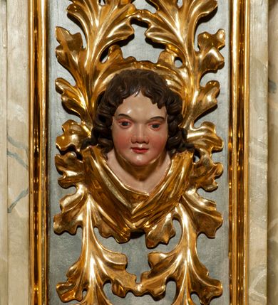 Zdjęcie nr 12: Drewniany, przyścienny ołtarz o formach architektonicznych, jednoosiowy, jednokondygnacyjny ze zwieńczeniem. Mensa murowana w kształcie prostopadłościanu zwieńczonego profilowanym gzymsem; antepedium prostokątne, w drewnianej, płaskorzeźbionej w motywy akantowe, złoconej ramie, dwustronne. Awers tłoczony, srebrzony, wykonany w technice papier mâché; rewers z malowanym na desce wyobrażeniem Veraicon na tle narzędzi męki. Tabernakulum na osi, złożone z mosiężnej, złoconej, sześciobocznej skrzynki w rozbudowanej, drewnianej obudowie o formach architektonicznych. Na nim tron wystawienia w kształcie niszy dekorowanej kratką, nakrytej kopułką z latarnią i przysłoniętej złapanymi po bokach kotarami. Na latarni rzeźbione przedstawienie pelikana karmiącego pisklęta własną krwią. Skrzynkę z tronem ulokowano na tle parawanu ustawionego na podwójnym cokole, ażurowego w górnej części, wypełnionego dekoracją roślinną, złączonego z kopułka spływami. 
Retabulum ołtarzowe drewniane wsparte na wysokim, dwudzielnym, murowanym cokole. Cokół w obudowie drewnianej, jego kondygnacje wydzielone wydatnymi, silnie występującymi przed lico gzymsami; mocno wysunięte ku przodowi części przednie. Ich lica z prostokątnymi płycinami mieszczącymi suchy akant; w części środkowej drugiej kondygnacji cokołu, dodatkowo pełnoplastyczne główki puttów. Na cokole ustawione zdwojone, złocone kolumny o skręconych trzonach i kompozytowych kapitelach. Pomiędzy nimi płyciny wypełnione dekoracją w formie podwieszonego wieńca, u jego szczytu putta pełniące rolę atlantów. Na tle płycin ustawione drewniane, złocone figury z lewej św. Zygmunta i z prawej św. Marii Magdaleny – patronów kościoła. Pole ołtarza z prostokątną niszą zamkniętą łukiem wyniesionym; ujętą płaskorzeźbioną, złoconą ramą zdobioną suchym akantem. W niszy pełnoplastyczny, polichromowany i złocony krucyfiks na aksamitnym tle, flankowany przez płaskorzeźbione wyobrażenia słońca i księżyca. Nisza zasuwana obrazem z Przemienieniem na górze Tabor, w drewnianej, złoconej sukience. Kolumny dźwigają pełne, wyłamane na osiach podpór belkowanie, z wydatnym, silnie profilowanym gzymsem; na jego osi złocony monogram „IHS” w otoku ze srebrzonych obłoków na tle promienistej glorii. Całość wieńczą fragmenty przerwanego przyczółka o formach wklęsło-wypukłych, z ażurową dekoracją z suchego akantu. Pomiędzy ramionami przyczółka złocona gloria promienista, w centrum której płaskorzeźbiona postać Boga Ojca siedzącego na srebrzonym obłoku ze srebrzoną gołębicą Ducha Świętego u stóp. Na ramionach glorii uskrzydlone główki puttów, niektóre na tle obłoków. Po bokach, na gzymsie siedzące postaci nagich, adorujących puttów. Ołtarz ujęty ażurowymi, złoconymi uszami z suchego akantu, w który wplecione są groteskowe putta trzymające pochodnie. Większość powierzchni ołtarza marmoryzowana, w kolorze jasnej, oliwkowej zieleni, z ciemniejszymi brązowymi elementami wypełniającymi płyciny. Złocenia w partiach ornamentów, kolumn oraz załamaniach profili elementów architektonicznych; srebrzone obłoki, części szat postaci i pelikan. 