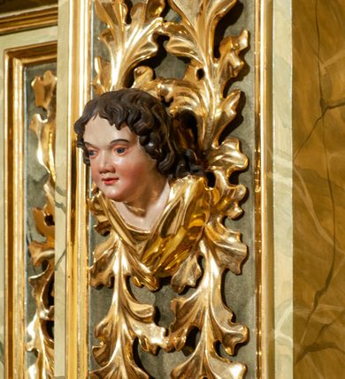 Zdjęcie nr 13: Drewniany, przyścienny ołtarz o formach architektonicznych, jednoosiowy, jednokondygnacyjny ze zwieńczeniem. Mensa murowana w kształcie prostopadłościanu zwieńczonego profilowanym gzymsem; antepedium prostokątne, w drewnianej, płaskorzeźbionej w motywy akantowe, złoconej ramie, dwustronne. Awers tłoczony, srebrzony, wykonany w technice papier mâché; rewers z malowanym na desce wyobrażeniem Veraicon na tle narzędzi męki. Tabernakulum na osi, złożone z mosiężnej, złoconej, sześciobocznej skrzynki w rozbudowanej, drewnianej obudowie o formach architektonicznych. Na nim tron wystawienia w kształcie niszy dekorowanej kratką, nakrytej kopułką z latarnią i przysłoniętej złapanymi po bokach kotarami. Na latarni rzeźbione przedstawienie pelikana karmiącego pisklęta własną krwią. Skrzynkę z tronem ulokowano na tle parawanu ustawionego na podwójnym cokole, ażurowego w górnej części, wypełnionego dekoracją roślinną, złączonego z kopułka spływami. 
Retabulum ołtarzowe drewniane wsparte na wysokim, dwudzielnym, murowanym cokole. Cokół w obudowie drewnianej, jego kondygnacje wydzielone wydatnymi, silnie występującymi przed lico gzymsami; mocno wysunięte ku przodowi części przednie. Ich lica z prostokątnymi płycinami mieszczącymi suchy akant; w części środkowej drugiej kondygnacji cokołu, dodatkowo pełnoplastyczne główki puttów. Na cokole ustawione zdwojone, złocone kolumny o skręconych trzonach i kompozytowych kapitelach. Pomiędzy nimi płyciny wypełnione dekoracją w formie podwieszonego wieńca, u jego szczytu putta pełniące rolę atlantów. Na tle płycin ustawione drewniane, złocone figury z lewej św. Zygmunta i z prawej św. Marii Magdaleny – patronów kościoła. Pole ołtarza z prostokątną niszą zamkniętą łukiem wyniesionym; ujętą płaskorzeźbioną, złoconą ramą zdobioną suchym akantem. W niszy pełnoplastyczny, polichromowany i złocony krucyfiks na aksamitnym tle, flankowany przez płaskorzeźbione wyobrażenia słońca i księżyca. Nisza zasuwana obrazem z Przemienieniem na górze Tabor, w drewnianej, złoconej sukience. Kolumny dźwigają pełne, wyłamane na osiach podpór belkowanie, z wydatnym, silnie profilowanym gzymsem; na jego osi złocony monogram „IHS” w otoku ze srebrzonych obłoków na tle promienistej glorii. Całość wieńczą fragmenty przerwanego przyczółka o formach wklęsło-wypukłych, z ażurową dekoracją z suchego akantu. Pomiędzy ramionami przyczółka złocona gloria promienista, w centrum której płaskorzeźbiona postać Boga Ojca siedzącego na srebrzonym obłoku ze srebrzoną gołębicą Ducha Świętego u stóp. Na ramionach glorii uskrzydlone główki puttów, niektóre na tle obłoków. Po bokach, na gzymsie siedzące postaci nagich, adorujących puttów. Ołtarz ujęty ażurowymi, złoconymi uszami z suchego akantu, w który wplecione są groteskowe putta trzymające pochodnie. Większość powierzchni ołtarza marmoryzowana, w kolorze jasnej, oliwkowej zieleni, z ciemniejszymi brązowymi elementami wypełniającymi płyciny. Złocenia w partiach ornamentów, kolumn oraz załamaniach profili elementów architektonicznych; srebrzone obłoki, części szat postaci i pelikan. 