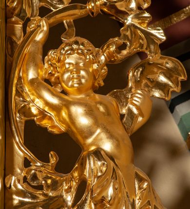 Zdjęcie nr 21: Drewniany, przyścienny ołtarz o formach architektonicznych, jednoosiowy, jednokondygnacyjny ze zwieńczeniem. Mensa murowana w kształcie prostopadłościanu zwieńczonego profilowanym gzymsem; antepedium prostokątne, w drewnianej, płaskorzeźbionej w motywy akantowe, złoconej ramie, dwustronne. Awers tłoczony, srebrzony, wykonany w technice papier mâché; rewers z malowanym na desce wyobrażeniem Veraicon na tle narzędzi męki. Tabernakulum na osi, złożone z mosiężnej, złoconej, sześciobocznej skrzynki w rozbudowanej, drewnianej obudowie o formach architektonicznych. Na nim tron wystawienia w kształcie niszy dekorowanej kratką, nakrytej kopułką z latarnią i przysłoniętej złapanymi po bokach kotarami. Na latarni rzeźbione przedstawienie pelikana karmiącego pisklęta własną krwią. Skrzynkę z tronem ulokowano na tle parawanu ustawionego na podwójnym cokole, ażurowego w górnej części, wypełnionego dekoracją roślinną, złączonego z kopułka spływami. 
Retabulum ołtarzowe drewniane wsparte na wysokim, dwudzielnym, murowanym cokole. Cokół w obudowie drewnianej, jego kondygnacje wydzielone wydatnymi, silnie występującymi przed lico gzymsami; mocno wysunięte ku przodowi części przednie. Ich lica z prostokątnymi płycinami mieszczącymi suchy akant; w części środkowej drugiej kondygnacji cokołu, dodatkowo pełnoplastyczne główki puttów. Na cokole ustawione zdwojone, złocone kolumny o skręconych trzonach i kompozytowych kapitelach. Pomiędzy nimi płyciny wypełnione dekoracją w formie podwieszonego wieńca, u jego szczytu putta pełniące rolę atlantów. Na tle płycin ustawione drewniane, złocone figury z lewej św. Zygmunta i z prawej św. Marii Magdaleny – patronów kościoła. Pole ołtarza z prostokątną niszą zamkniętą łukiem wyniesionym; ujętą płaskorzeźbioną, złoconą ramą zdobioną suchym akantem. W niszy pełnoplastyczny, polichromowany i złocony krucyfiks na aksamitnym tle, flankowany przez płaskorzeźbione wyobrażenia słońca i księżyca. Nisza zasuwana obrazem z Przemienieniem na górze Tabor, w drewnianej, złoconej sukience. Kolumny dźwigają pełne, wyłamane na osiach podpór belkowanie, z wydatnym, silnie profilowanym gzymsem; na jego osi złocony monogram „IHS” w otoku ze srebrzonych obłoków na tle promienistej glorii. Całość wieńczą fragmenty przerwanego przyczółka o formach wklęsło-wypukłych, z ażurową dekoracją z suchego akantu. Pomiędzy ramionami przyczółka złocona gloria promienista, w centrum której płaskorzeźbiona postać Boga Ojca siedzącego na srebrzonym obłoku ze srebrzoną gołębicą Ducha Świętego u stóp. Na ramionach glorii uskrzydlone główki puttów, niektóre na tle obłoków. Po bokach, na gzymsie siedzące postaci nagich, adorujących puttów. Ołtarz ujęty ażurowymi, złoconymi uszami z suchego akantu, w który wplecione są groteskowe putta trzymające pochodnie. Większość powierzchni ołtarza marmoryzowana, w kolorze jasnej, oliwkowej zieleni, z ciemniejszymi brązowymi elementami wypełniającymi płyciny. Złocenia w partiach ornamentów, kolumn oraz załamaniach profili elementów architektonicznych; srebrzone obłoki, części szat postaci i pelikan. 