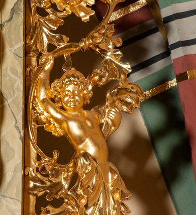 Zdjęcie nr 18: Drewniany, przyścienny ołtarz o formach architektonicznych, jednoosiowy, jednokondygnacyjny ze zwieńczeniem. Mensa murowana w kształcie prostopadłościanu zwieńczonego profilowanym gzymsem; antepedium prostokątne, w drewnianej, płaskorzeźbionej w motywy akantowe, złoconej ramie, dwustronne. Awers tłoczony, srebrzony, wykonany w technice papier mâché; rewers z malowanym na desce wyobrażeniem Veraicon na tle narzędzi męki. Tabernakulum na osi, złożone z mosiężnej, złoconej, sześciobocznej skrzynki w rozbudowanej, drewnianej obudowie o formach architektonicznych. Na nim tron wystawienia w kształcie niszy dekorowanej kratką, nakrytej kopułką z latarnią i przysłoniętej złapanymi po bokach kotarami. Na latarni rzeźbione przedstawienie pelikana karmiącego pisklęta własną krwią. Skrzynkę z tronem ulokowano na tle parawanu ustawionego na podwójnym cokole, ażurowego w górnej części, wypełnionego dekoracją roślinną, złączonego z kopułka spływami. 
Retabulum ołtarzowe drewniane wsparte na wysokim, dwudzielnym, murowanym cokole. Cokół w obudowie drewnianej, jego kondygnacje wydzielone wydatnymi, silnie występującymi przed lico gzymsami; mocno wysunięte ku przodowi części przednie. Ich lica z prostokątnymi płycinami mieszczącymi suchy akant; w części środkowej drugiej kondygnacji cokołu, dodatkowo pełnoplastyczne główki puttów. Na cokole ustawione zdwojone, złocone kolumny o skręconych trzonach i kompozytowych kapitelach. Pomiędzy nimi płyciny wypełnione dekoracją w formie podwieszonego wieńca, u jego szczytu putta pełniące rolę atlantów. Na tle płycin ustawione drewniane, złocone figury z lewej św. Zygmunta i z prawej św. Marii Magdaleny – patronów kościoła. Pole ołtarza z prostokątną niszą zamkniętą łukiem wyniesionym; ujętą płaskorzeźbioną, złoconą ramą zdobioną suchym akantem. W niszy pełnoplastyczny, polichromowany i złocony krucyfiks na aksamitnym tle, flankowany przez płaskorzeźbione wyobrażenia słońca i księżyca. Nisza zasuwana obrazem z Przemienieniem na górze Tabor, w drewnianej, złoconej sukience. Kolumny dźwigają pełne, wyłamane na osiach podpór belkowanie, z wydatnym, silnie profilowanym gzymsem; na jego osi złocony monogram „IHS” w otoku ze srebrzonych obłoków na tle promienistej glorii. Całość wieńczą fragmenty przerwanego przyczółka o formach wklęsło-wypukłych, z ażurową dekoracją z suchego akantu. Pomiędzy ramionami przyczółka złocona gloria promienista, w centrum której płaskorzeźbiona postać Boga Ojca siedzącego na srebrzonym obłoku ze srebrzoną gołębicą Ducha Świętego u stóp. Na ramionach glorii uskrzydlone główki puttów, niektóre na tle obłoków. Po bokach, na gzymsie siedzące postaci nagich, adorujących puttów. Ołtarz ujęty ażurowymi, złoconymi uszami z suchego akantu, w który wplecione są groteskowe putta trzymające pochodnie. Większość powierzchni ołtarza marmoryzowana, w kolorze jasnej, oliwkowej zieleni, z ciemniejszymi brązowymi elementami wypełniającymi płyciny. Złocenia w partiach ornamentów, kolumn oraz załamaniach profili elementów architektonicznych; srebrzone obłoki, części szat postaci i pelikan. 