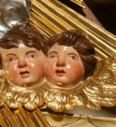 Zdjęcie nr 41: Drewniany, przyścienny ołtarz o formach architektonicznych, jednoosiowy, jednokondygnacyjny ze zwieńczeniem. Mensa murowana w kształcie prostopadłościanu zwieńczonego profilowanym gzymsem; antepedium prostokątne, w drewnianej, płaskorzeźbionej w motywy akantowe, złoconej ramie, dwustronne. Awers tłoczony, srebrzony, wykonany w technice papier mâché; rewers z malowanym na desce wyobrażeniem Veraicon na tle narzędzi męki. Tabernakulum na osi, złożone z mosiężnej, złoconej, sześciobocznej skrzynki w rozbudowanej, drewnianej obudowie o formach architektonicznych. Na nim tron wystawienia w kształcie niszy dekorowanej kratką, nakrytej kopułką z latarnią i przysłoniętej złapanymi po bokach kotarami. Na latarni rzeźbione przedstawienie pelikana karmiącego pisklęta własną krwią. Skrzynkę z tronem ulokowano na tle parawanu ustawionego na podwójnym cokole, ażurowego w górnej części, wypełnionego dekoracją roślinną, złączonego z kopułka spływami. 
Retabulum ołtarzowe drewniane wsparte na wysokim, dwudzielnym, murowanym cokole. Cokół w obudowie drewnianej, jego kondygnacje wydzielone wydatnymi, silnie występującymi przed lico gzymsami; mocno wysunięte ku przodowi części przednie. Ich lica z prostokątnymi płycinami mieszczącymi suchy akant; w części środkowej drugiej kondygnacji cokołu, dodatkowo pełnoplastyczne główki puttów. Na cokole ustawione zdwojone, złocone kolumny o skręconych trzonach i kompozytowych kapitelach. Pomiędzy nimi płyciny wypełnione dekoracją w formie podwieszonego wieńca, u jego szczytu putta pełniące rolę atlantów. Na tle płycin ustawione drewniane, złocone figury z lewej św. Zygmunta i z prawej św. Marii Magdaleny – patronów kościoła. Pole ołtarza z prostokątną niszą zamkniętą łukiem wyniesionym; ujętą płaskorzeźbioną, złoconą ramą zdobioną suchym akantem. W niszy pełnoplastyczny, polichromowany i złocony krucyfiks na aksamitnym tle, flankowany przez płaskorzeźbione wyobrażenia słońca i księżyca. Nisza zasuwana obrazem z Przemienieniem na górze Tabor, w drewnianej, złoconej sukience. Kolumny dźwigają pełne, wyłamane na osiach podpór belkowanie, z wydatnym, silnie profilowanym gzymsem; na jego osi złocony monogram „IHS” w otoku ze srebrzonych obłoków na tle promienistej glorii. Całość wieńczą fragmenty przerwanego przyczółka o formach wklęsło-wypukłych, z ażurową dekoracją z suchego akantu. Pomiędzy ramionami przyczółka złocona gloria promienista, w centrum której płaskorzeźbiona postać Boga Ojca siedzącego na srebrzonym obłoku ze srebrzoną gołębicą Ducha Świętego u stóp. Na ramionach glorii uskrzydlone główki puttów, niektóre na tle obłoków. Po bokach, na gzymsie siedzące postaci nagich, adorujących puttów. Ołtarz ujęty ażurowymi, złoconymi uszami z suchego akantu, w który wplecione są groteskowe putta trzymające pochodnie. Większość powierzchni ołtarza marmoryzowana, w kolorze jasnej, oliwkowej zieleni, z ciemniejszymi brązowymi elementami wypełniającymi płyciny. Złocenia w partiach ornamentów, kolumn oraz załamaniach profili elementów architektonicznych; srebrzone obłoki, części szat postaci i pelikan. 