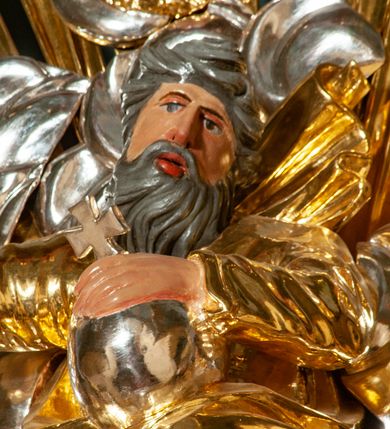 Zdjęcie nr 56: Drewniany, przyścienny ołtarz o formach architektonicznych, jednoosiowy, jednokondygnacyjny ze zwieńczeniem. Mensa murowana w kształcie prostopadłościanu zwieńczonego profilowanym gzymsem; antepedium prostokątne, w drewnianej, płaskorzeźbionej w motywy akantowe, złoconej ramie, dwustronne. Awers tłoczony, srebrzony, wykonany w technice papier mâché; rewers z malowanym na desce wyobrażeniem Veraicon na tle narzędzi męki. Tabernakulum na osi, złożone z mosiężnej, złoconej, sześciobocznej skrzynki w rozbudowanej, drewnianej obudowie o formach architektonicznych. Na nim tron wystawienia w kształcie niszy dekorowanej kratką, nakrytej kopułką z latarnią i przysłoniętej złapanymi po bokach kotarami. Na latarni rzeźbione przedstawienie pelikana karmiącego pisklęta własną krwią. Skrzynkę z tronem ulokowano na tle parawanu ustawionego na podwójnym cokole, ażurowego w górnej części, wypełnionego dekoracją roślinną, złączonego z kopułka spływami. 
Retabulum ołtarzowe drewniane wsparte na wysokim, dwudzielnym, murowanym cokole. Cokół w obudowie drewnianej, jego kondygnacje wydzielone wydatnymi, silnie występującymi przed lico gzymsami; mocno wysunięte ku przodowi części przednie. Ich lica z prostokątnymi płycinami mieszczącymi suchy akant; w części środkowej drugiej kondygnacji cokołu, dodatkowo pełnoplastyczne główki puttów. Na cokole ustawione zdwojone, złocone kolumny o skręconych trzonach i kompozytowych kapitelach. Pomiędzy nimi płyciny wypełnione dekoracją w formie podwieszonego wieńca, u jego szczytu putta pełniące rolę atlantów. Na tle płycin ustawione drewniane, złocone figury z lewej św. Zygmunta i z prawej św. Marii Magdaleny – patronów kościoła. Pole ołtarza z prostokątną niszą zamkniętą łukiem wyniesionym; ujętą płaskorzeźbioną, złoconą ramą zdobioną suchym akantem. W niszy pełnoplastyczny, polichromowany i złocony krucyfiks na aksamitnym tle, flankowany przez płaskorzeźbione wyobrażenia słońca i księżyca. Nisza zasuwana obrazem z Przemienieniem na górze Tabor, w drewnianej, złoconej sukience. Kolumny dźwigają pełne, wyłamane na osiach podpór belkowanie, z wydatnym, silnie profilowanym gzymsem; na jego osi złocony monogram „IHS” w otoku ze srebrzonych obłoków na tle promienistej glorii. Całość wieńczą fragmenty przerwanego przyczółka o formach wklęsło-wypukłych, z ażurową dekoracją z suchego akantu. Pomiędzy ramionami przyczółka złocona gloria promienista, w centrum której płaskorzeźbiona postać Boga Ojca siedzącego na srebrzonym obłoku ze srebrzoną gołębicą Ducha Świętego u stóp. Na ramionach glorii uskrzydlone główki puttów, niektóre na tle obłoków. Po bokach, na gzymsie siedzące postaci nagich, adorujących puttów. Ołtarz ujęty ażurowymi, złoconymi uszami z suchego akantu, w który wplecione są groteskowe putta trzymające pochodnie. Większość powierzchni ołtarza marmoryzowana, w kolorze jasnej, oliwkowej zieleni, z ciemniejszymi brązowymi elementami wypełniającymi płyciny. Złocenia w partiach ornamentów, kolumn oraz załamaniach profili elementów architektonicznych; srebrzone obłoki, części szat postaci i pelikan. 