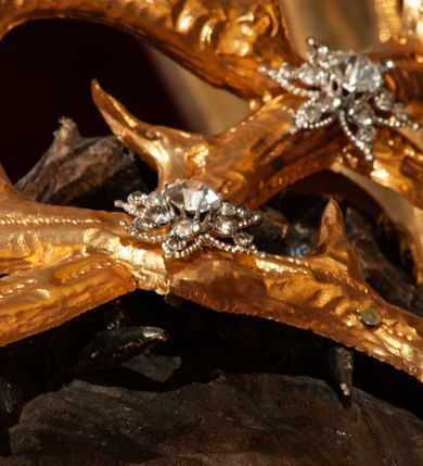 Zdjęcie nr 107: Drewniany, przyścienny ołtarz o formach architektonicznych, jednoosiowy, jednokondygnacyjny ze zwieńczeniem. Mensa murowana w kształcie prostopadłościanu zwieńczonego profilowanym gzymsem; antepedium prostokątne, w drewnianej, płaskorzeźbionej w motywy akantowe, złoconej ramie, dwustronne. Awers tłoczony, srebrzony, wykonany w technice papier mâché; rewers z malowanym na desce wyobrażeniem Veraicon na tle narzędzi męki. Tabernakulum na osi, złożone z mosiężnej, złoconej, sześciobocznej skrzynki w rozbudowanej, drewnianej obudowie o formach architektonicznych. Na nim tron wystawienia w kształcie niszy dekorowanej kratką, nakrytej kopułką z latarnią i przysłoniętej złapanymi po bokach kotarami. Na latarni rzeźbione przedstawienie pelikana karmiącego pisklęta własną krwią. Skrzynkę z tronem ulokowano na tle parawanu ustawionego na podwójnym cokole, ażurowego w górnej części, wypełnionego dekoracją roślinną, złączonego z kopułka spływami. 
Retabulum ołtarzowe drewniane wsparte na wysokim, dwudzielnym, murowanym cokole. Cokół w obudowie drewnianej, jego kondygnacje wydzielone wydatnymi, silnie występującymi przed lico gzymsami; mocno wysunięte ku przodowi części przednie. Ich lica z prostokątnymi płycinami mieszczącymi suchy akant; w części środkowej drugiej kondygnacji cokołu, dodatkowo pełnoplastyczne główki puttów. Na cokole ustawione zdwojone, złocone kolumny o skręconych trzonach i kompozytowych kapitelach. Pomiędzy nimi płyciny wypełnione dekoracją w formie podwieszonego wieńca, u jego szczytu putta pełniące rolę atlantów. Na tle płycin ustawione drewniane, złocone figury z lewej św. Zygmunta i z prawej św. Marii Magdaleny – patronów kościoła. Pole ołtarza z prostokątną niszą zamkniętą łukiem wyniesionym; ujętą płaskorzeźbioną, złoconą ramą zdobioną suchym akantem. W niszy pełnoplastyczny, polichromowany i złocony krucyfiks na aksamitnym tle, flankowany przez płaskorzeźbione wyobrażenia słońca i księżyca. Nisza zasuwana obrazem z Przemienieniem na górze Tabor, w drewnianej, złoconej sukience. Kolumny dźwigają pełne, wyłamane na osiach podpór belkowanie, z wydatnym, silnie profilowanym gzymsem; na jego osi złocony monogram „IHS” w otoku ze srebrzonych obłoków na tle promienistej glorii. Całość wieńczą fragmenty przerwanego przyczółka o formach wklęsło-wypukłych, z ażurową dekoracją z suchego akantu. Pomiędzy ramionami przyczółka złocona gloria promienista, w centrum której płaskorzeźbiona postać Boga Ojca siedzącego na srebrzonym obłoku ze srebrzoną gołębicą Ducha Świętego u stóp. Na ramionach glorii uskrzydlone główki puttów, niektóre na tle obłoków. Po bokach, na gzymsie siedzące postaci nagich, adorujących puttów. Ołtarz ujęty ażurowymi, złoconymi uszami z suchego akantu, w który wplecione są groteskowe putta trzymające pochodnie. Większość powierzchni ołtarza marmoryzowana, w kolorze jasnej, oliwkowej zieleni, z ciemniejszymi brązowymi elementami wypełniającymi płyciny. Złocenia w partiach ornamentów, kolumn oraz załamaniach profili elementów architektonicznych; srebrzone obłoki, części szat postaci i pelikan. 