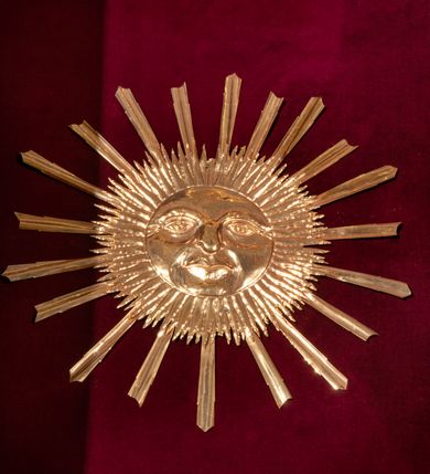 Zdjęcie nr 74: Drewniany, przyścienny ołtarz o formach architektonicznych, jednoosiowy, jednokondygnacyjny ze zwieńczeniem. Mensa murowana w kształcie prostopadłościanu zwieńczonego profilowanym gzymsem; antepedium prostokątne, w drewnianej, płaskorzeźbionej w motywy akantowe, złoconej ramie, dwustronne. Awers tłoczony, srebrzony, wykonany w technice papier mâché; rewers z malowanym na desce wyobrażeniem Veraicon na tle narzędzi męki. Tabernakulum na osi, złożone z mosiężnej, złoconej, sześciobocznej skrzynki w rozbudowanej, drewnianej obudowie o formach architektonicznych. Na nim tron wystawienia w kształcie niszy dekorowanej kratką, nakrytej kopułką z latarnią i przysłoniętej złapanymi po bokach kotarami. Na latarni rzeźbione przedstawienie pelikana karmiącego pisklęta własną krwią. Skrzynkę z tronem ulokowano na tle parawanu ustawionego na podwójnym cokole, ażurowego w górnej części, wypełnionego dekoracją roślinną, złączonego z kopułka spływami. 
Retabulum ołtarzowe drewniane wsparte na wysokim, dwudzielnym, murowanym cokole. Cokół w obudowie drewnianej, jego kondygnacje wydzielone wydatnymi, silnie występującymi przed lico gzymsami; mocno wysunięte ku przodowi części przednie. Ich lica z prostokątnymi płycinami mieszczącymi suchy akant; w części środkowej drugiej kondygnacji cokołu, dodatkowo pełnoplastyczne główki puttów. Na cokole ustawione zdwojone, złocone kolumny o skręconych trzonach i kompozytowych kapitelach. Pomiędzy nimi płyciny wypełnione dekoracją w formie podwieszonego wieńca, u jego szczytu putta pełniące rolę atlantów. Na tle płycin ustawione drewniane, złocone figury z lewej św. Zygmunta i z prawej św. Marii Magdaleny – patronów kościoła. Pole ołtarza z prostokątną niszą zamkniętą łukiem wyniesionym; ujętą płaskorzeźbioną, złoconą ramą zdobioną suchym akantem. W niszy pełnoplastyczny, polichromowany i złocony krucyfiks na aksamitnym tle, flankowany przez płaskorzeźbione wyobrażenia słońca i księżyca. Nisza zasuwana obrazem z Przemienieniem na górze Tabor, w drewnianej, złoconej sukience. Kolumny dźwigają pełne, wyłamane na osiach podpór belkowanie, z wydatnym, silnie profilowanym gzymsem; na jego osi złocony monogram „IHS” w otoku ze srebrzonych obłoków na tle promienistej glorii. Całość wieńczą fragmenty przerwanego przyczółka o formach wklęsło-wypukłych, z ażurową dekoracją z suchego akantu. Pomiędzy ramionami przyczółka złocona gloria promienista, w centrum której płaskorzeźbiona postać Boga Ojca siedzącego na srebrzonym obłoku ze srebrzoną gołębicą Ducha Świętego u stóp. Na ramionach glorii uskrzydlone główki puttów, niektóre na tle obłoków. Po bokach, na gzymsie siedzące postaci nagich, adorujących puttów. Ołtarz ujęty ażurowymi, złoconymi uszami z suchego akantu, w który wplecione są groteskowe putta trzymające pochodnie. Większość powierzchni ołtarza marmoryzowana, w kolorze jasnej, oliwkowej zieleni, z ciemniejszymi brązowymi elementami wypełniającymi płyciny. Złocenia w partiach ornamentów, kolumn oraz załamaniach profili elementów architektonicznych; srebrzone obłoki, części szat postaci i pelikan. 