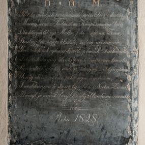 Zdjęcie nr 1: Prostokątna tablica z czarnego wapienia w otoku z rytych i złoconych liści dębu. W jej polu napis wykonany kursywą „D(EO) O(PTIMO) M(AXIMO) / Pod tą swiętych przeznaczeń smiertelną odzieżą / Maciey, wraz z Tadeuszem, Kwapiszewscy! leżą / Dla których tkliwa Matka, przywiązana Żona, / Smutny ten napis kładzie, żalem ucisniona / Grób Ich pokrywszy łzami, pomnik zbudowała, / Żeby, tak drogiey straty pamięć, wiecznie trwała. / Przechodniu! gdy Cię czułość wstrzyma nad tym głazem, / Uczciy, obecne zwłoki, pobożnym wyrazem, / I westchniy, za te duszę: by Pan! Nieba Ziemi, / Złączył je wsród Swej Chwały z Aniołami swemi. / Roku 1828.”
