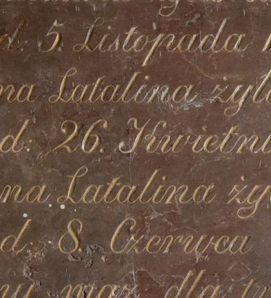 Zdjęcie nr 1: Kamienna tablica epitafijna w kształcie leżącego prostokąta wypełniona inskrypcją „Anna Latalina żyła lat 22. / zmarła d(nia) 5. Listopada 1849. r(oku) / Maryianna Latalina żyła lat 30. / zmarła d(nia) 26. Kwietnia 1855 r(oku) / Maryianna Latalina żyła lat 38. / zmarła d(nia) 8. Czerwca 1864. r(oku) / wdzięczny mąż dla trzech Żon / wraz z dziećmi te pamiątke stawia / prosi o westchnienie do Boga”. 