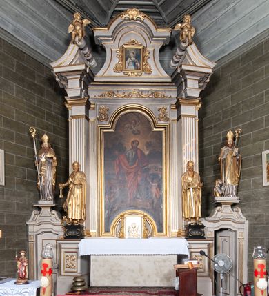 Zdjęcie nr 1: Ołtarz architektoniczny, jednoosiowy, jednokondygnacyjny, ze zwieńczeniem i bramkami bocznymi. Nastawa ujęta czworobocznymi kanelowanymi filarami umieszczonymi na tle kanelowanych pilastrów. Filary dźwigają pełne belkowanie i profilowany gzyms, występujące nad podporami, przerwane nad częścią środkową. Przy filarach rzeźby: po lewej Św. Piotr, po prawej Św. Paweł. W polu środkowym nastawy nisza w kształcie stojącego prostokąta zamkniętego łukiem półkolistym nadwieszonym, w profilowanej złoconej ramie. W niszy obraz z przedstawieniem św. Jakub Apostoła. Zwieńczenie w formie aedikuli zamkniętej łukiem półkolistym nadwieszonym, ujętej spływami wolutowymi. Pośrodku obraz w kształcie stojącego prostokąta, w ozdobnej ramie, z przedstawieniem św. Tekli w półpostaci. W osiach filarów odcinki przerwanego przyczółka, na których rzeźby siedzących puttów. Po bokach retabulum bramki z prześwitami w kształcie prostokąta zamkniętego łukiem kotarowym ściętym, w których osadzone płycinowe drzwi. Ponad bramkami konsole ujęte wolutami, na których rzeźby: po lewej Św. Wojciech, po prawej Św. Stanisław Biskup z Piotrowinem. W przyłuczach obrazu środkowego i we fryzie nałożone rzeźbione motywy rocaille’ów. Struktura nastawy w kolorze kremowym, ramy obrazów, kanelury, motywy ornamentalne złocone. 