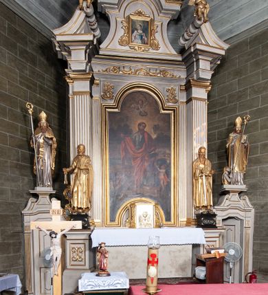 Zdjęcie nr 3: Ołtarz architektoniczny, jednoosiowy, jednokondygnacyjny, ze zwieńczeniem i bramkami bocznymi. Nastawa ujęta czworobocznymi kanelowanymi filarami umieszczonymi na tle kanelowanych pilastrów. Filary dźwigają pełne belkowanie i profilowany gzyms, występujące nad podporami, przerwane nad częścią środkową. Przy filarach rzeźby: po lewej Św. Piotr, po prawej Św. Paweł. W polu środkowym nastawy nisza w kształcie stojącego prostokąta zamkniętego łukiem półkolistym nadwieszonym, w profilowanej złoconej ramie. W niszy obraz z przedstawieniem św. Jakub Apostoła. Zwieńczenie w formie aedikuli zamkniętej łukiem półkolistym nadwieszonym, ujętej spływami wolutowymi. Pośrodku obraz w kształcie stojącego prostokąta, w ozdobnej ramie, z przedstawieniem św. Tekli w półpostaci. W osiach filarów odcinki przerwanego przyczółka, na których rzeźby siedzących puttów. Po bokach retabulum bramki z prześwitami w kształcie prostokąta zamkniętego łukiem kotarowym ściętym, w których osadzone płycinowe drzwi. Ponad bramkami konsole ujęte wolutami, na których rzeźby: po lewej Św. Wojciech, po prawej Św. Stanisław Biskup z Piotrowinem. W przyłuczach obrazu środkowego i we fryzie nałożone rzeźbione motywy rocaille’ów. Struktura nastawy w kolorze kremowym, ramy obrazów, kanelury, motywy ornamentalne złocone. 