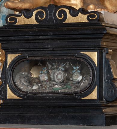 Zdjęcie nr 34: Ołtarz architektoniczny, jednoosiowy, jednokondygnacyjny, ze zwieńczeniem i bramkami bocznymi. Nastawa ujęta czworobocznymi kanelowanymi filarami umieszczonymi na tle kanelowanych pilastrów. Filary dźwigają pełne belkowanie i profilowany gzyms, występujące nad podporami, przerwane nad częścią środkową. Przy filarach rzeźby: po lewej Św. Piotr, po prawej Św. Paweł. W polu środkowym nastawy nisza w kształcie stojącego prostokąta zamkniętego łukiem półkolistym nadwieszonym, w profilowanej złoconej ramie. W niszy obraz z przedstawieniem św. Jakub Apostoła. Zwieńczenie w formie aedikuli zamkniętej łukiem półkolistym nadwieszonym, ujętej spływami wolutowymi. Pośrodku obraz w kształcie stojącego prostokąta, w ozdobnej ramie, z przedstawieniem św. Tekli w półpostaci. W osiach filarów odcinki przerwanego przyczółka, na których rzeźby siedzących puttów. Po bokach retabulum bramki z prześwitami w kształcie prostokąta zamkniętego łukiem kotarowym ściętym, w których osadzone płycinowe drzwi. Ponad bramkami konsole ujęte wolutami, na których rzeźby: po lewej Św. Wojciech, po prawej Św. Stanisław Biskup z Piotrowinem. W przyłuczach obrazu środkowego i we fryzie nałożone rzeźbione motywy rocaille’ów. Struktura nastawy w kolorze kremowym, ramy obrazów, kanelury, motywy ornamentalne złocone. 