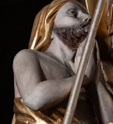 Zdjęcie nr 4: Rzeźba pełnoplastyczna, przyścienna; przedstawienie św. Stanisława Biskupa w całej postaci, frontalnie, w stroju pontyfikalnym. Prawą ręką błogosławi, lewą trzyma księgę i podtrzymuje pastorał. Po jego prawej stronie, u stóp, ukazany Piotrowin w półpostaci, ze złożonymi do modlitwy dłońmi. Karnacje w kolorze naturalnym, szaty pozłocone i srebrzyste.