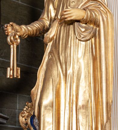 Zdjęcie nr 5: Rzeźba pełnoplastyczna, przyścienna; przedstawienie św. Piotra Apostoła w całej postaci, frontalnie, stoi boso w lekkim kontrapoście, z głową skierowaną lekko w lewo. Twarz starszego mężczyzny, pociągła, z wysokim czołem, okolona wianuszkiem sięgających ramion kręconych włosów i obfitym zarostem. Ręce ugięte w łokciach, w prawej trzyma dwa duże klucze. Ubrany w długą suknię z długimi, wąskimi rękawami, na lewe ramię zarzucony płaszcz przerzucony przez lewą rękę. Cała rzeźba wraz z karnacjami pozłocona.