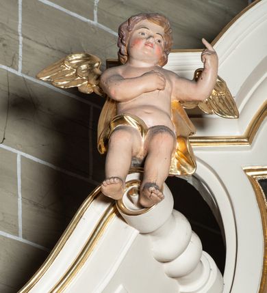 Zdjęcie nr 26: Ołtarz architektoniczny, jednoosiowy, jednokondygnacyjny, ze zwieńczeniem. Mensa drewniana, umieszczona na prostopadłościennej skrzyni; antependium z prostokątną płyciną. Nastawa ujęta czworobocznymi, kanelowanymi filarami, ustawionymi ukośnie na tle kanelowanych pilastrów. Filary dźwigają pełne belkowanie i profilowany gzyms, występujące nad nimi. Przy filarach od czoła na wysokich, prostopadłościennych postumentach rzeźby dwóch świętych jezuickich w czarnych sutannach. W polu środkowym nastawy prostokątne nisza ujęta złoconą ramą, w której rzeźba Najświętsze Serce Jezusa.  Zwieńczenie w kształcie aedikuli zamkniętej łukiem półkolistym nadwieszonym i o wklęsłych bokach; pośrodku obraz z przedstawieniem świętego męczennika powtarzający kształt aedikuli. Po bokach, w osiach filarów, odcinki przerwanego przyczółka, na których siedzą dwa putta. Struktura malowana na biało, detale architektoniczne i ornamenty złocone. 