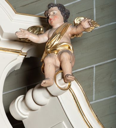 Zdjęcie nr 28: Ołtarz architektoniczny, jednoosiowy, jednokondygnacyjny, ze zwieńczeniem. Mensa drewniana, umieszczona na prostopadłościennej skrzyni; antependium z prostokątną płyciną. Nastawa ujęta czworobocznymi, kanelowanymi filarami, ustawionymi ukośnie na tle kanelowanych pilastrów. Filary dźwigają pełne belkowanie i profilowany gzyms, występujące nad nimi. Przy filarach od czoła na wysokich, prostopadłościennych postumentach rzeźby dwóch świętych jezuickich w czarnych sutannach. W polu środkowym nastawy prostokątne nisza ujęta złoconą ramą, w której rzeźba Najświętsze Serce Jezusa.  Zwieńczenie w kształcie aedikuli zamkniętej łukiem półkolistym nadwieszonym i o wklęsłych bokach; pośrodku obraz z przedstawieniem świętego męczennika powtarzający kształt aedikuli. Po bokach, w osiach filarów, odcinki przerwanego przyczółka, na których siedzą dwa putta. Struktura malowana na biało, detale architektoniczne i ornamenty złocone. 