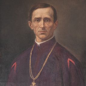 Zdjęcie nr 1: Obraz o kształcie pionowego prostokąta, przedstawiający księdza Zygmunta Goliana. Kapłan ukazany w popiersiu, zwrócony w trzech czwartych w prawo. Twarz pociągła, szczupła, o wyrazistych rysach. Oczy zapadnięte, brwi opadające ku dołowi, nos prosty, wąskie usta. Włosy brązowe, krótkie, odsłaniające uszy, z przedziałkiem po lewej stronie, zaczesane na prawy bok. Ksiądz jest ubrany w fioletową sutannę z różowymi akcentami na linii barków. Na szyi ma zawieszony na podwójnym łańcuchu krzyż. Tło ciemne, gładkie, delikatnie rozjaśnione wokół sylwetki księdza. Obraz oprawiony w profilowaną, czarną, częściowo złoconą ramę, na dole której przymocowana tabliczka z napisem „Ks(iądz) Zygmunt Golian / proboszcz / 1881-1885”.