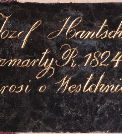 Zdjęcie nr 1: Tablica epitafijna w kształcie leżącego prostokąta. Na tablicy inskrypcja „Józef Hantschel / zmarły R(oku) 1824. / prosi o Westchnienie.”