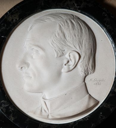 Zdjęcie nr 2: Epitafium w kształcie leżącego prostokąta z profilowanym obramieniem z uszakami. Na osi w górnej części owalny medalion z profilem zmarłego. Pośrodku tablicy inskrypcja: &quot;Pamięci KS(KSIĘDZA) ZYGMUNTA GOLIANA / NIEZRÓWNANYCH CNÓT MĘŻA KAPŁANA, OBYWATELA / *1824_ +1885. / OJCU PARAFII – ODNOWICIELOWI KOŚCIOŁA – / OZDOBIE KAZALNICY – OPIEKUNOWI BIEDNYCH – / W DOWÓD NAJGŁĘBSZEJ CZCI I ŻALU / PARAFIANIE&quot;. W prawym dolnym rogu sygnatura kamieniarza: &quot;E(DWARD) STEHLIK&quot;. W dolnej części medalionu sygnatura: &quot;M(arceli) Guyski / 1886&quot;. 