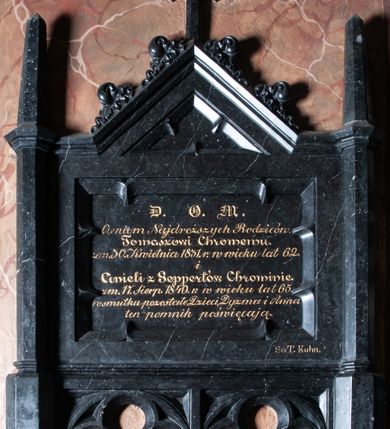 Zdjęcie nr 1: Epitafium przyścienne w kształcie leżącego prostokąta, flankowanego przez pięcioboczne sterczyny. Od dołu dwa maswerki trójlistne. Powyżej tablica z inskrypcją: "D)EO) O(PTIMO) M(AXIMO) / Cieniom Najdroższych Rodziców. / Tomaszowi Chromemu. zm(arłemu) 30. Kwietnia 1831. r(oku) w wieku lat 62. / i / Anieli z Seppertów Chrominie. zm(arłej) 17. Sierp(nia) 1849 r(oku) w wieku lat 65. / w smutku pozostałe Dzieci, Dyzma i Anna / ten pomnik poświęcają. Zwieńczenie w formie trójkątnego przyczółka z krzyżem pośrodku oraz żabkami po bokach. W prawym dolnym rogu epitafium sygnatura: "Sc(ulpsit): T. Kuhn.".