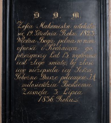 Zdjęcie nr 1: Tablica epitafijna w kształcie stojącego prostokąta w profilowanej ramie. Na tablicy inskrypcja  „D(EO) O(PTIMO) M(AXIMO) / Zofia Makomeska urodziła / się 19. Grudnia Roku. 1823. / Wierna Bogu pełna w nim / ufności i Kochaiąca go; /przeżywsży Lat 13. wyrwana / iest z tego świata by złość / iego niezepsuła iey Serca / Pobożne Dusze polecaycie JĄ / miłosierdziu Boskiemu. / Zasnęła 3. Lipca / 1836. Roku.” 
