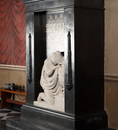 Zdjęcie nr 2: Pomnik w kształcie stojącego prostopadłościanu, umieszczony na niskim cokole, z belkowaniem. Zwieńczenie w formie trójkątnego przyczółka z płaskorzeźbą uskrzydlonej klepsydry pośrodku, flankowane motywem jaskółczego ogona. W polu środkowym pomnika widoczna nisza flankowana motywem odwróconych płonących pochodni. W niej rzeźba przedstawiająca w profilu klęczącą przy urnie kobietę, ubraną w togę i płaszcz zarzucony na głowę, okrywający plecy i częściowo urnę. Twarz pełna, z długim nosem, gęstymi, kręconymi włosami do ramion. Urna w typie greckiej amfory pokryta dołem liśćmi akantu na przemian z pięciopłatowymi kwiatami, góra fryzem z wicią roślinną. Nad płaskorzeźbą inskrycpcja: &quot;D(EO) O(PTIMO) M(AXIMO) / Józefowi Gawin / Niesiołowskiemu Dziedzicowi Dóbr Siercza i Klasna  w Wieku lat 46. dnia 19. Marca 1824. r(oku) zmarłemu / Czuła Żona; / Anna z Barów  Przychockich Niesiołowska; w dowód niewygasłey Pamięci i Żalu; ten Pomnik z proźbą / o westchnie za Dusze Jego / złożyła.&quot;