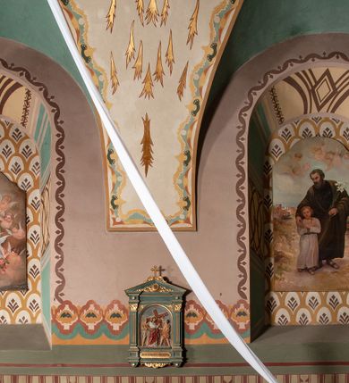 Zdjęcie nr 1: Prezbiterium: 
Sklepienie kolebkowe z lunetami; trójprzęsłowe. Pola malowane  są na kolor biały z centralnie umieszczonymi kolistymi medalionami. W przęśle pierwszym od ołtarza znajduje się motyw krzyża greckiego na tle promienistej glorii; w drugim gołębica Ducha Świętego na tle analogicznej glorii zamknięta w polu przypominającym sześciolistny kwiat o błękitno-złotych płatkach; w trzecim znak Trójcy Świętej w formie trzech przecinających się okręgów z napisem „TRI/NI/TAS”, otoczonych promieniami i płomienistymi półokręgami. Pozostałe partie pól sklepienia wypełnione są złoconymi językami ognia. Wokół pól sklepienia biegnie ornament geometryczny w kolorze turkusowym z elementami ugru i ultramaryny. Lunety malowane są na kolor jasnoniebieski. W każdej z nich znajdują się medaliony o kształcie zbliżonym do czwórliścia, wewnątrz których, od wschodu jest: słońce, planeta, gwiazda, księżyc, monogram Chrystusa, napis „CA/RI/TAS”.  Ściany boczne w około połowie wysokości podzielone na dwa poziomy. Dolny wypełniony jest geometryczną dekoracją w formie fryzu ze złoconych rombów, naprzemiennie większych i mniejszych. Wewnątrz figur równoramienne krzyże oraz motyw uproszczonych liści. Fryz ujęty od góry i dołu abstrakcyjną dekoracją o charakterze geometrycznym. Tła malowane są na kolor ciemnoczerwony oraz zielony. Poziom górny malowany jest na bladoróżowo. Na wysokości parapetów okiennych fryz ze stylizowanych motywów kwiatowych w kolorze żółtym, zielonym i brązowym. W ościeżach dekoracja ramowa w kolorze turkusowym i bladożółtym wzbogacona o malowane ciemniejszą farbą motywy geometryczne. Okna ściany południowej zastąpione blendami; w nich motyw karpiej łuski wypełnionej palmetą.

Łuk arkady tęczowej:
Na licu arkady tęczowej znajduje się figuralne przedstawienie stygmatyzacji św. Franciszka. Z lewej strony św. Franciszek, zwrócony w lewą stronę, z rozłożonymi szeroko rękami i prawą nogą cofniętą do tyłu. Ubrany w brązowy habit franciszkański. Z prawej strony Chrystus, ukazany naturalnej wielkości, jako cherubin o dużych, czerwonych skrzydłach. Z jego ran wychodzą promienie tworzące stygmaty na ciele świętego. Scena rozgrywa się na kamienistej drodze, na tle płomieni. Kompozycja ujęta otokiem z białych chmur. Na podłuczu arkady symetryczna dekoracja geometryczna w formie motywu „jodełki” przedzielonego wstęgą. W osi ośmioboczne pole ze znakiem krzyża greckiego z napisem „Cristus/Jesus”. Kolorystyka utrzymana w ciemnej zieleni, ceglastej czerwieni oraz w kolorze złotym.

Nawa główna:
Sklepienie kolebkowe z lunetami, czteroprzęsłowe. Pola malowane kolorem jasnoniebieskim. Cała długość nawy połączona dekoracyjnym pasem w kolorach turkusowym, szafirowym oraz żółtym. W każdym z przęseł pośrodku czteorolistne  pole otoczone glorią promienistą zawierające znaki, od wschodu: Alfa i Omega, monogram maryjny, kielich z hostią, IHS. Lunety malowane na jasnożółto, pośrodku każdej owoidalne pole w kolorze szafirowym: od wschodu i zachodu po dwóch stronach korona i napis „VITA / AETERNA”, od południa waga i napis „IUSTI/TIA”, dalej miecz i napis „FORTI\TUDO”, od północy beczka i napis „TEM/PE/RANTIA, wąż i napis „PRUDENTIA”. Obramienia lunet z motywem abstrakcyjnym. Pasy gurtów z ludowymi motywami kwiatowymi i kłosami zboża na żółtym tle. Ściany boczne w partii cokołu malowane są na kolor różowy, powyżej aż do linii parapetów okiennych: miodowo-żółty. Na obramieniach arkadowych nisz jest stylizowana dekoracja roślinna, w podłuczach i ościeżach arkad dekoracja analogiczna do tej z podłucza arkady tęczy. Na ścianach pomiędzy niszami godła franciszkańskie zamknięte w okrągłych medalionach. Na linii parapetów geometryczny fryz z przecinających się arkadek uzupełnionych o motywy roślinne. W rozglifieniach okiennych naprzemiennie motywy geometryczne i roślinne w kolorach błękitnym, pomarańczoym i dwóch odcieniach żółci. Arkada chóru muzycznego o podziale ramowym w kolorach jasnozielonym, pomarańczowym i żółtym.