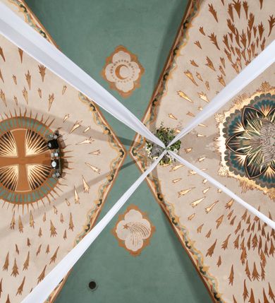 Zdjęcie nr 6: Prezbiterium: 
Sklepienie kolebkowe z lunetami; trójprzęsłowe. Pola malowane  są na kolor biały z centralnie umieszczonymi kolistymi medalionami. W przęśle pierwszym od ołtarza znajduje się motyw krzyża greckiego na tle promienistej glorii; w drugim gołębica Ducha Świętego na tle analogicznej glorii zamknięta w polu przypominającym sześciolistny kwiat o błękitno-złotych płatkach; w trzecim znak Trójcy Świętej w formie trzech przecinających się okręgów z napisem „TRI/NI/TAS”, otoczonych promieniami i płomienistymi półokręgami. Pozostałe partie pól sklepienia wypełnione są złoconymi językami ognia. Wokół pól sklepienia biegnie ornament geometryczny w kolorze turkusowym z elementami ugru i ultramaryny. Lunety malowane są na kolor jasnoniebieski. W każdej z nich znajdują się medaliony o kształcie zbliżonym do czwórliścia, wewnątrz których, od wschodu jest: słońce, planeta, gwiazda, księżyc, monogram Chrystusa, napis „CA/RI/TAS”.  Ściany boczne w około połowie wysokości podzielone na dwa poziomy. Dolny wypełniony jest geometryczną dekoracją w formie fryzu ze złoconych rombów, naprzemiennie większych i mniejszych. Wewnątrz figur równoramienne krzyże oraz motyw uproszczonych liści. Fryz ujęty od góry i dołu abstrakcyjną dekoracją o charakterze geometrycznym. Tła malowane są na kolor ciemnoczerwony oraz zielony. Poziom górny malowany jest na bladoróżowo. Na wysokości parapetów okiennych fryz ze stylizowanych motywów kwiatowych w kolorze żółtym, zielonym i brązowym. W ościeżach dekoracja ramowa w kolorze turkusowym i bladożółtym wzbogacona o malowane ciemniejszą farbą motywy geometryczne. Okna ściany południowej zastąpione blendami; w nich motyw karpiej łuski wypełnionej palmetą.

Łuk arkady tęczowej:
Na licu arkady tęczowej znajduje się figuralne przedstawienie stygmatyzacji św. Franciszka. Z lewej strony św. Franciszek, zwrócony w lewą stronę, z rozłożonymi szeroko rękami i prawą nogą cofniętą do tyłu. Ubrany w brązowy habit franciszkański. Z prawej strony Chrystus, ukazany naturalnej wielkości, jako cherubin o dużych, czerwonych skrzydłach. Z jego ran wychodzą promienie tworzące stygmaty na ciele świętego. Scena rozgrywa się na kamienistej drodze, na tle płomieni. Kompozycja ujęta otokiem z białych chmur. Na podłuczu arkady symetryczna dekoracja geometryczna w formie motywu „jodełki” przedzielonego wstęgą. W osi ośmioboczne pole ze znakiem krzyża greckiego z napisem „Cristus/Jesus”. Kolorystyka utrzymana w ciemnej zieleni, ceglastej czerwieni oraz w kolorze złotym.

Nawa główna:
Sklepienie kolebkowe z lunetami, czteroprzęsłowe. Pola malowane kolorem jasnoniebieskim. Cała długość nawy połączona dekoracyjnym pasem w kolorach turkusowym, szafirowym oraz żółtym. W każdym z przęseł pośrodku czteorolistne  pole otoczone glorią promienistą zawierające znaki, od wschodu: Alfa i Omega, monogram maryjny, kielich z hostią, IHS. Lunety malowane na jasnożółto, pośrodku każdej owoidalne pole w kolorze szafirowym: od wschodu i zachodu po dwóch stronach korona i napis „VITA / AETERNA”, od południa waga i napis „IUSTI/TIA”, dalej miecz i napis „FORTI\TUDO”, od północy beczka i napis „TEM/PE/RANTIA, wąż i napis „PRUDENTIA”. Obramienia lunet z motywem abstrakcyjnym. Pasy gurtów z ludowymi motywami kwiatowymi i kłosami zboża na żółtym tle. Ściany boczne w partii cokołu malowane są na kolor różowy, powyżej aż do linii parapetów okiennych: miodowo-żółty. Na obramieniach arkadowych nisz jest stylizowana dekoracja roślinna, w podłuczach i ościeżach arkad dekoracja analogiczna do tej z podłucza arkady tęczy. Na ścianach pomiędzy niszami godła franciszkańskie zamknięte w okrągłych medalionach. Na linii parapetów geometryczny fryz z przecinających się arkadek uzupełnionych o motywy roślinne. W rozglifieniach okiennych naprzemiennie motywy geometryczne i roślinne w kolorach błękitnym, pomarańczoym i dwóch odcieniach żółci. Arkada chóru muzycznego o podziale ramowym w kolorach jasnozielonym, pomarańczowym i żółtym.