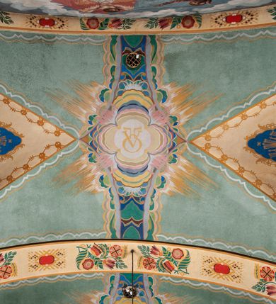 Zdjęcie nr 18: Prezbiterium: 
Sklepienie kolebkowe z lunetami; trójprzęsłowe. Pola malowane  są na kolor biały z centralnie umieszczonymi kolistymi medalionami. W przęśle pierwszym od ołtarza znajduje się motyw krzyża greckiego na tle promienistej glorii; w drugim gołębica Ducha Świętego na tle analogicznej glorii zamknięta w polu przypominającym sześciolistny kwiat o błękitno-złotych płatkach; w trzecim znak Trójcy Świętej w formie trzech przecinających się okręgów z napisem „TRI/NI/TAS”, otoczonych promieniami i płomienistymi półokręgami. Pozostałe partie pól sklepienia wypełnione są złoconymi językami ognia. Wokół pól sklepienia biegnie ornament geometryczny w kolorze turkusowym z elementami ugru i ultramaryny. Lunety malowane są na kolor jasnoniebieski. W każdej z nich znajdują się medaliony o kształcie zbliżonym do czwórliścia, wewnątrz których, od wschodu jest: słońce, planeta, gwiazda, księżyc, monogram Chrystusa, napis „CA/RI/TAS”.  Ściany boczne w około połowie wysokości podzielone na dwa poziomy. Dolny wypełniony jest geometryczną dekoracją w formie fryzu ze złoconych rombów, naprzemiennie większych i mniejszych. Wewnątrz figur równoramienne krzyże oraz motyw uproszczonych liści. Fryz ujęty od góry i dołu abstrakcyjną dekoracją o charakterze geometrycznym. Tła malowane są na kolor ciemnoczerwony oraz zielony. Poziom górny malowany jest na bladoróżowo. Na wysokości parapetów okiennych fryz ze stylizowanych motywów kwiatowych w kolorze żółtym, zielonym i brązowym. W ościeżach dekoracja ramowa w kolorze turkusowym i bladożółtym wzbogacona o malowane ciemniejszą farbą motywy geometryczne. Okna ściany południowej zastąpione blendami; w nich motyw karpiej łuski wypełnionej palmetą.

Łuk arkady tęczowej:
Na licu arkady tęczowej znajduje się figuralne przedstawienie stygmatyzacji św. Franciszka. Z lewej strony św. Franciszek, zwrócony w lewą stronę, z rozłożonymi szeroko rękami i prawą nogą cofniętą do tyłu. Ubrany w brązowy habit franciszkański. Z prawej strony Chrystus, ukazany naturalnej wielkości, jako cherubin o dużych, czerwonych skrzydłach. Z jego ran wychodzą promienie tworzące stygmaty na ciele świętego. Scena rozgrywa się na kamienistej drodze, na tle płomieni. Kompozycja ujęta otokiem z białych chmur. Na podłuczu arkady symetryczna dekoracja geometryczna w formie motywu „jodełki” przedzielonego wstęgą. W osi ośmioboczne pole ze znakiem krzyża greckiego z napisem „Cristus/Jesus”. Kolorystyka utrzymana w ciemnej zieleni, ceglastej czerwieni oraz w kolorze złotym.

Nawa główna:
Sklepienie kolebkowe z lunetami, czteroprzęsłowe. Pola malowane kolorem jasnoniebieskim. Cała długość nawy połączona dekoracyjnym pasem w kolorach turkusowym, szafirowym oraz żółtym. W każdym z przęseł pośrodku czteorolistne  pole otoczone glorią promienistą zawierające znaki, od wschodu: Alfa i Omega, monogram maryjny, kielich z hostią, IHS. Lunety malowane na jasnożółto, pośrodku każdej owoidalne pole w kolorze szafirowym: od wschodu i zachodu po dwóch stronach korona i napis „VITA / AETERNA”, od południa waga i napis „IUSTI/TIA”, dalej miecz i napis „FORTI\TUDO”, od północy beczka i napis „TEM/PE/RANTIA, wąż i napis „PRUDENTIA”. Obramienia lunet z motywem abstrakcyjnym. Pasy gurtów z ludowymi motywami kwiatowymi i kłosami zboża na żółtym tle. Ściany boczne w partii cokołu malowane są na kolor różowy, powyżej aż do linii parapetów okiennych: miodowo-żółty. Na obramieniach arkadowych nisz jest stylizowana dekoracja roślinna, w podłuczach i ościeżach arkad dekoracja analogiczna do tej z podłucza arkady tęczy. Na ścianach pomiędzy niszami godła franciszkańskie zamknięte w okrągłych medalionach. Na linii parapetów geometryczny fryz z przecinających się arkadek uzupełnionych o motywy roślinne. W rozglifieniach okiennych naprzemiennie motywy geometryczne i roślinne w kolorach błękitnym, pomarańczoym i dwóch odcieniach żółci. Arkada chóru muzycznego o podziale ramowym w kolorach jasnozielonym, pomarańczowym i żółtym.