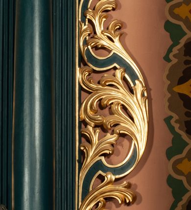 Zdjęcie nr 6: Ołtarz przyścienny, architektoniczny, jednokondygnacyjny, jednoosiowy, ze zwieńczeniem.  Mensa w formie prostopadłościanu. Antepedium proste z płaskorzeźbionym przedstawieniem Baranka Bożego w polu. Retabulum umieszczone na zdwojonym cokole, flankowane kolumnami, ustawionymi na tle zwielokrotnionych pilastrów podtrzymujących wyłamane belkowanie; na osi kolumn przerwany wolutowy przyczółek. W polu głównym nastawy płytka wnęka, ujęte złoconą i profilowaną ramą w kształcie stojącego prostokąta zamkniętego łukiem wklęsło-wypukłym z uskokami. Pośrodku obraz „Św. Kinga”. W górnej części ramy złocony kartusz. Zwieńczenie o delikatnie wklęsłych bokach ujętych spływami wolutowymi, zamknięte łukiem nadwieszonym. Nad nim złocona muszla palmetowa między dwoma spływami wolutowymi. W polu zwieńczenia obraz „Św. Walenty” w ramie o fantazyjnym wykroju. Retabulum flankowane po bokach ażurowymi uszami utworzonymi z liści akantu i przeplatającej je karbowanej wstęgi. Podpory ustawione na bazach, kapitele kompozytowe, trzony kolumn gładkie, natomiast trzony pilastrów kanelowane. Struktura malowana w kolorze ciemnozielonym, ornamenty i detale złocone.

