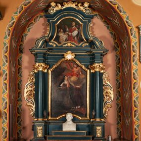 Zdjęcie nr 1: Ołtarz przyścienny, architektoniczny, jednokondygnacyjny, jednoosiowy, ze zwieńczeniem.  Mensa w formie prostopadłościanu. Antepedium proste z płaskorzeźbionym przedstawieniem Baranka Bożego w polu. Retabulum umieszczone na zdwojonym cokole, flankowane kolumnami, ustawionymi na tle zwielokrotnionych pilastrów podtrzymujących wyłamane belkowanie; na osi kolumn przerwany wolutowy przyczółek. W polu głównym nastawy płytka wnęka, ujęte złoconą i profilowaną ramą w kształcie stojącego prostokąta zamkniętego łukiem wklęsło-wypukłym z uskokami. Pośrodku obraz „Św. Kinga”. W górnej części ramy złocony kartusz. Zwieńczenie o delikatnie wklęsłych bokach ujętych spływami wolutowymi, zamknięte łukiem nadwieszonym. Nad nim złocona muszla palmetowa między dwoma spływami wolutowymi. W polu zwieńczenia obraz „Św. Walenty” w ramie o fantazyjnym wykroju. Retabulum flankowane po bokach ażurowymi uszami utworzonymi z liści akantu i przeplatającej je karbowanej wstęgi. Podpory ustawione na bazach, kapitele kompozytowe, trzony kolumn gładkie, natomiast trzony pilastrów kanelowane. Struktura malowana w kolorze ciemnozielonym, ornamenty i detale złocone.

