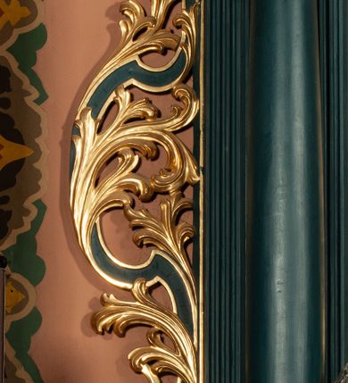 Zdjęcie nr 5: Ołtarz przyścienny, architektoniczny, jednokondygnacyjny, jednoosiowy, ze zwieńczeniem.  Mensa w formie prostopadłościanu. Antepedium proste z płaskorzeźbionym przedstawieniem Baranka Bożego w polu. Retabulum umieszczone na zdwojonym cokole, flankowane kolumnami, ustawionymi na tle zwielokrotnionych pilastrów podtrzymujących wyłamane belkowanie; na osi kolumn przerwany wolutowy przyczółek. W polu głównym nastawy płytka wnęka, ujęte złoconą i profilowaną ramą w kształcie stojącego prostokąta zamkniętego łukiem wklęsło-wypukłym z uskokami. Pośrodku obraz „Św. Kinga”. W górnej części ramy złocony kartusz. Zwieńczenie o delikatnie wklęsłych bokach ujętych spływami wolutowymi, zamknięte łukiem nadwieszonym. Nad nim złocona muszla palmetowa między dwoma spływami wolutowymi. W polu zwieńczenia obraz „Św. Walenty” w ramie o fantazyjnym wykroju. Retabulum flankowane po bokach ażurowymi uszami utworzonymi z liści akantu i przeplatającej je karbowanej wstęgi. Podpory ustawione na bazach, kapitele kompozytowe, trzony kolumn gładkie, natomiast trzony pilastrów kanelowane. Struktura malowana w kolorze ciemnozielonym, ornamenty i detale złocone.

