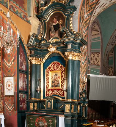Zdjęcie nr 3: Ołtarz przyścienny, architektoniczny, jednokondygnacyjny, jednoosiowy, ze zwieńczeniem.  Mensa w formie prostopadłościanu. Antepedium malowane: pośrodku medalion otoczony baldachimem utworzonym z królewskiego płaszcza, spiętego u góry koroną, z chwostami po bokach. W polu scena ukazująca odnalezienie pierścienia św. Kingi w bryle soli. Po bokach medalionu wolutowo zakręcona wić roślinna zakończona wazonami z kwiatami. Całość ukazana na ciemnozielonym tle. Tabernakulum w formie prostopadłościennej skrzynki, ustawione na niskim cokoliku, flankowane parą pilastrów z bazami, kanelowanymi trzonami i kapitelami kompozytowymi podtrzymującymi proste belkowanie z trójkątnym przyczółkiem. Zwieńczenie w formie prostopadłościennego postumentu, na którym ustawiony krucyfiks. Drzwiczki w kształcie stojącego prostokąta, zamkniętego łukiem nadwieszonym. W polu monogram Marii, gwiazda i wieniec z róż. Nad drzwiczkami, w przyłuczach dwie gałązki róż. Retabulum umieszczone na zdwojonym cokole, flankowane kolumnami, ustawionymi na tle zwielokrotnionych pilastrów podtrzymujących wyłamane belkowanie; na osi kolumn przerwany wolutowy przyczółek. W polu głównym nastawy płytka wnęka, ujęta złoconą i profilowaną ramą w kształcie stojącego prostokąta zamkniętego łukiem wklęsło-wypukłym z uskokami. Pośrodku obraz „Matki Boskiej Nieustającej Pomocy”, a na zasuwie obraz „Matki Boskiej Niepokalanie Poczętej”. W górnej części ramy złocony kartusz z napisem „MARIA”. Zwieńczenie o delikatnie wklęsłych bokach ujętych spływami wolutowymi i rzędem kampanul, zamknięte łukiem nadwieszonym z profilowanym gzymsem. Nad nim złocona muszla palmetowa ujęta dwoma spływami wolutowymi. U szczytu zwieńczenia, po bokach ustawione dwa wazoniki z kwiatami. W polu zwieńczenia obraz „Św. Jacek” ujęty w ramę o fantazyjnym wykroju.  Podpory ustawione na bazach, kapietle kompozytowe, trzony kolumn gładkie, natomiast trzony pilastrów kanelowane. Struktura malowana w kolorze ciemnozielonym, ornamenty i detale złocone.
