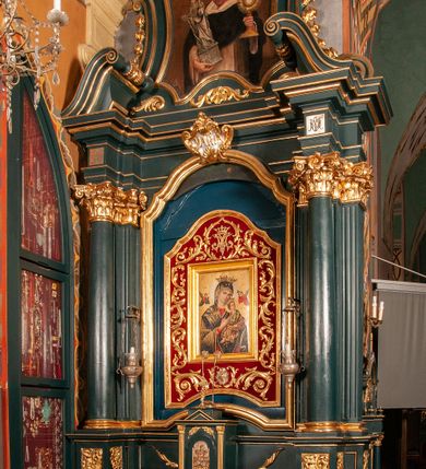 Zdjęcie nr 2: Ołtarz przyścienny, architektoniczny, jednokondygnacyjny, jednoosiowy, ze zwieńczeniem.  Mensa w formie prostopadłościanu. Antepedium malowane: pośrodku medalion otoczony baldachimem utworzonym z królewskiego płaszcza, spiętego u góry koroną, z chwostami po bokach. W polu scena ukazująca odnalezienie pierścienia św. Kingi w bryle soli. Po bokach medalionu wolutowo zakręcona wić roślinna zakończona wazonami z kwiatami. Całość ukazana na ciemnozielonym tle. Tabernakulum w formie prostopadłościennej skrzynki, ustawione na niskim cokoliku, flankowane parą pilastrów z bazami, kanelowanymi trzonami i kapitelami kompozytowymi podtrzymującymi proste belkowanie z trójkątnym przyczółkiem. Zwieńczenie w formie prostopadłościennego postumentu, na którym ustawiony krucyfiks. Drzwiczki w kształcie stojącego prostokąta, zamkniętego łukiem nadwieszonym. W polu monogram Marii, gwiazda i wieniec z róż. Nad drzwiczkami, w przyłuczach dwie gałązki róż. Retabulum umieszczone na zdwojonym cokole, flankowane kolumnami, ustawionymi na tle zwielokrotnionych pilastrów podtrzymujących wyłamane belkowanie; na osi kolumn przerwany wolutowy przyczółek. W polu głównym nastawy płytka wnęka, ujęta złoconą i profilowaną ramą w kształcie stojącego prostokąta zamkniętego łukiem wklęsło-wypukłym z uskokami. Pośrodku obraz „Matki Boskiej Nieustającej Pomocy”, a na zasuwie obraz „Matki Boskiej Niepokalanie Poczętej”. W górnej części ramy złocony kartusz z napisem „MARIA”. Zwieńczenie o delikatnie wklęsłych bokach ujętych spływami wolutowymi i rzędem kampanul, zamknięte łukiem nadwieszonym z profilowanym gzymsem. Nad nim złocona muszla palmetowa ujęta dwoma spływami wolutowymi. U szczytu zwieńczenia, po bokach ustawione dwa wazoniki z kwiatami. W polu zwieńczenia obraz „Św. Jacek” ujęty w ramę o fantazyjnym wykroju.  Podpory ustawione na bazach, kapietle kompozytowe, trzony kolumn gładkie, natomiast trzony pilastrów kanelowane. Struktura malowana w kolorze ciemnozielonym, ornamenty i detale złocone.
