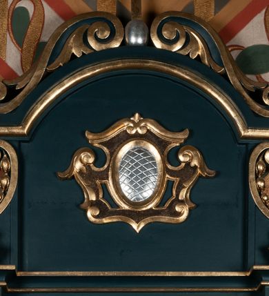 Zdjęcie nr 3: Ołtarz przyścienny, architektoniczny, jednoosiowy, jednokondygnacyjny ze zwieńczeniem. Mensa w formie wysokiego prostopadłościanu. Retabulum ustawione na cokole, ujęte smukłymi kolumnami kompozytowymi stojącymi na bazach. Podpory dźwigają odcinki niepełnego belkowania z rautami w partii fryzu; na nich ustawione niewielkie wazony. W polu prostokątna, złocona rama z wizerunkiem św. Maksymiliana Marii Kolbego. Zwieńczenie o nieregularnym kształcie z bokami ujętymi spływami wolutowymi, zamknięte profilowanym gzymsem w postaci łuku nadwieszonego. Na nim dwie akantowe woluty o układzie przeciwstawnym oraz prosty krzyż. W polu zwieńczenia srebrzony kartusz z kratką wewnątrz. Nastawa ujęta po bokach ażurowymi, akantowymi uszami z motywem woluty. Imposty dekorowane rautami. Struktura malowana na kolor ciemnozielony, ornamenty i detale złocone. 