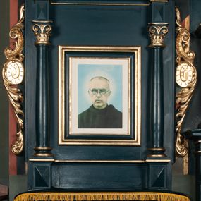 Zdjęcie nr 1: Ołtarz przyścienny, architektoniczny, jednoosiowy, jednokondygnacyjny ze zwieńczeniem. Mensa w formie wysokiego prostopadłościanu. Retabulum ustawione na cokole, ujęte smukłymi kolumnami kompozytowymi stojącymi na bazach. Podpory dźwigają odcinki niepełnego belkowania z rautami w partii fryzu; na nich ustawione niewielkie wazony. W polu prostokątna, złocona rama z wizerunkiem św. Maksymiliana Marii Kolbego. Zwieńczenie o nieregularnym kształcie z bokami ujętymi spływami wolutowymi, zamknięte profilowanym gzymsem w postaci łuku nadwieszonego. Na nim dwie akantowe woluty o układzie przeciwstawnym oraz prosty krzyż. W polu zwieńczenia srebrzony kartusz z kratką wewnątrz. Nastawa ujęta po bokach ażurowymi, akantowymi uszami z motywem woluty. Imposty dekorowane rautami. Struktura malowana na kolor ciemnozielony, ornamenty i detale złocone. 