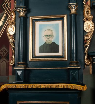 Zdjęcie nr 4: Ołtarz przyścienny, architektoniczny, jednoosiowy, jednokondygnacyjny ze zwieńczeniem. Mensa w formie wysokiego prostopadłościanu. Retabulum ustawione na cokole, ujęte smukłymi kolumnami kompozytowymi stojącymi na bazach. Podpory dźwigają odcinki niepełnego belkowania z rautami w partii fryzu; na nich ustawione niewielkie wazony. W polu prostokątna, złocona rama z wizerunkiem św. Maksymiliana Marii Kolbego. Zwieńczenie o nieregularnym kształcie z bokami ujętymi spływami wolutowymi, zamknięte profilowanym gzymsem w postaci łuku nadwieszonego. Na nim dwie akantowe woluty o układzie przeciwstawnym oraz prosty krzyż. W polu zwieńczenia srebrzony kartusz z kratką wewnątrz. Nastawa ujęta po bokach ażurowymi, akantowymi uszami z motywem woluty. Imposty dekorowane rautami. Struktura malowana na kolor ciemnozielony, ornamenty i detale złocone. 